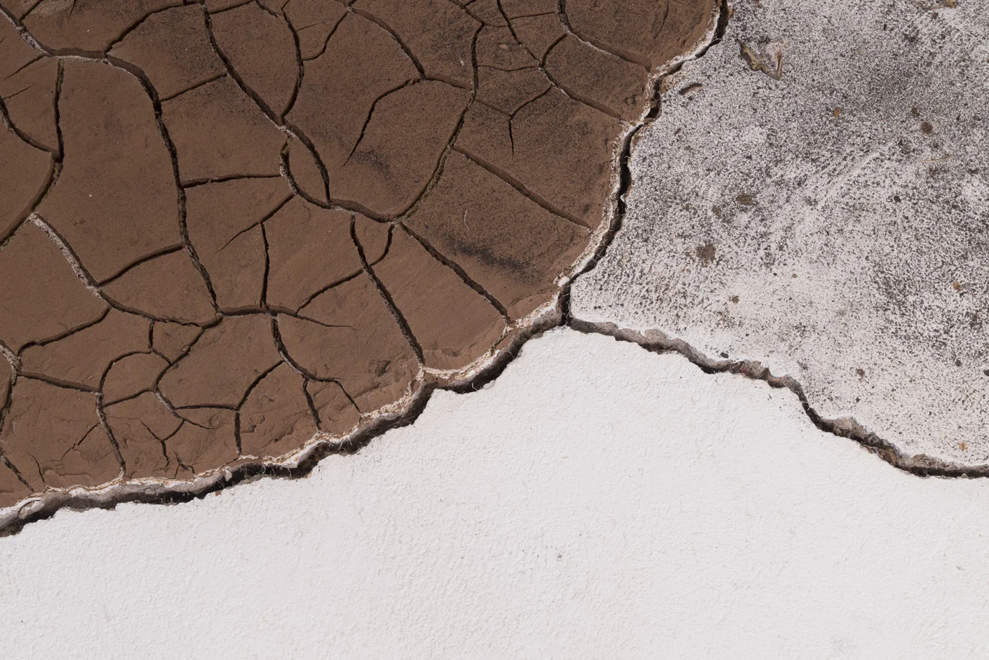 Installation detail of cracked earth and ash bounded by cracks in gallery floor.
