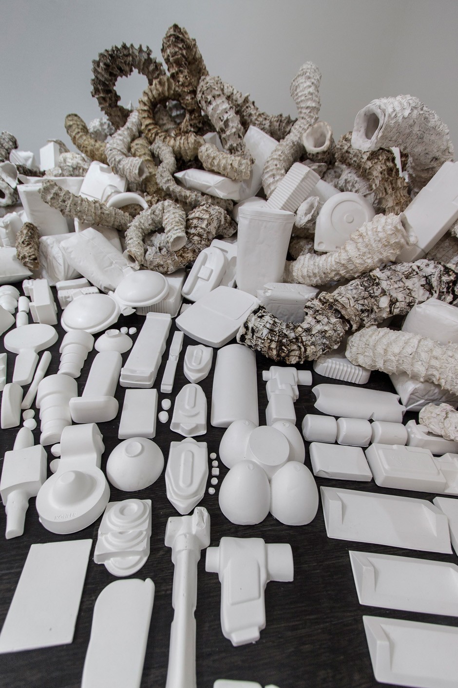   Seemingly Unconnected Events V4  2007- 2014 (ongoing)  DETAIL.Hundreds of plaster casts of organic forms stacked and interlaced with consumer goods casts, 15 x 7 x 2.5’  Installation for Re Imagine, Three Person Exhibition, Epsten Gallery, Village 