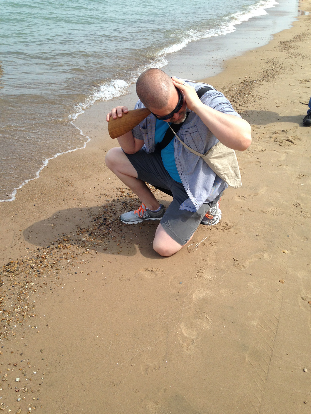  Listening to water lapping the Tony Prinz Beach, hand carved wooden burl trumpet in use, walk planned and led by Karen McCoy, sponsored by Alternative Spacetime 1300 (artist residency), Chicago, IL. (photo: Karen McCoy) 