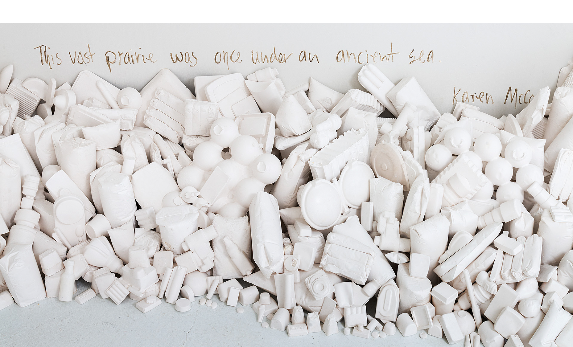  Installation detail of consumer goods casts “washed up” against the walls with text. 