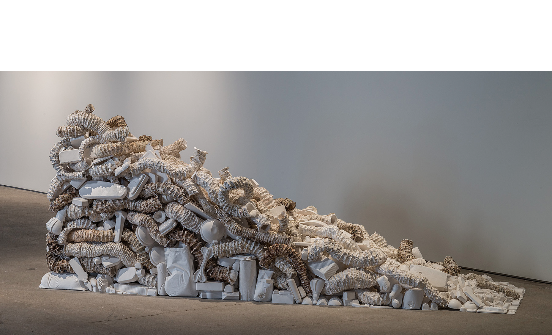   Seemingly Unconnected Events: The Wedge&nbsp;  2007- 2015  Hundreds of plaster casts of organic forms interwoven and interconnected with consumer goods casts*, 90 x 30 x 45”.&nbsp;  Installation at H&amp;R Block Artspace, Kansas City, MO, Fall 2015