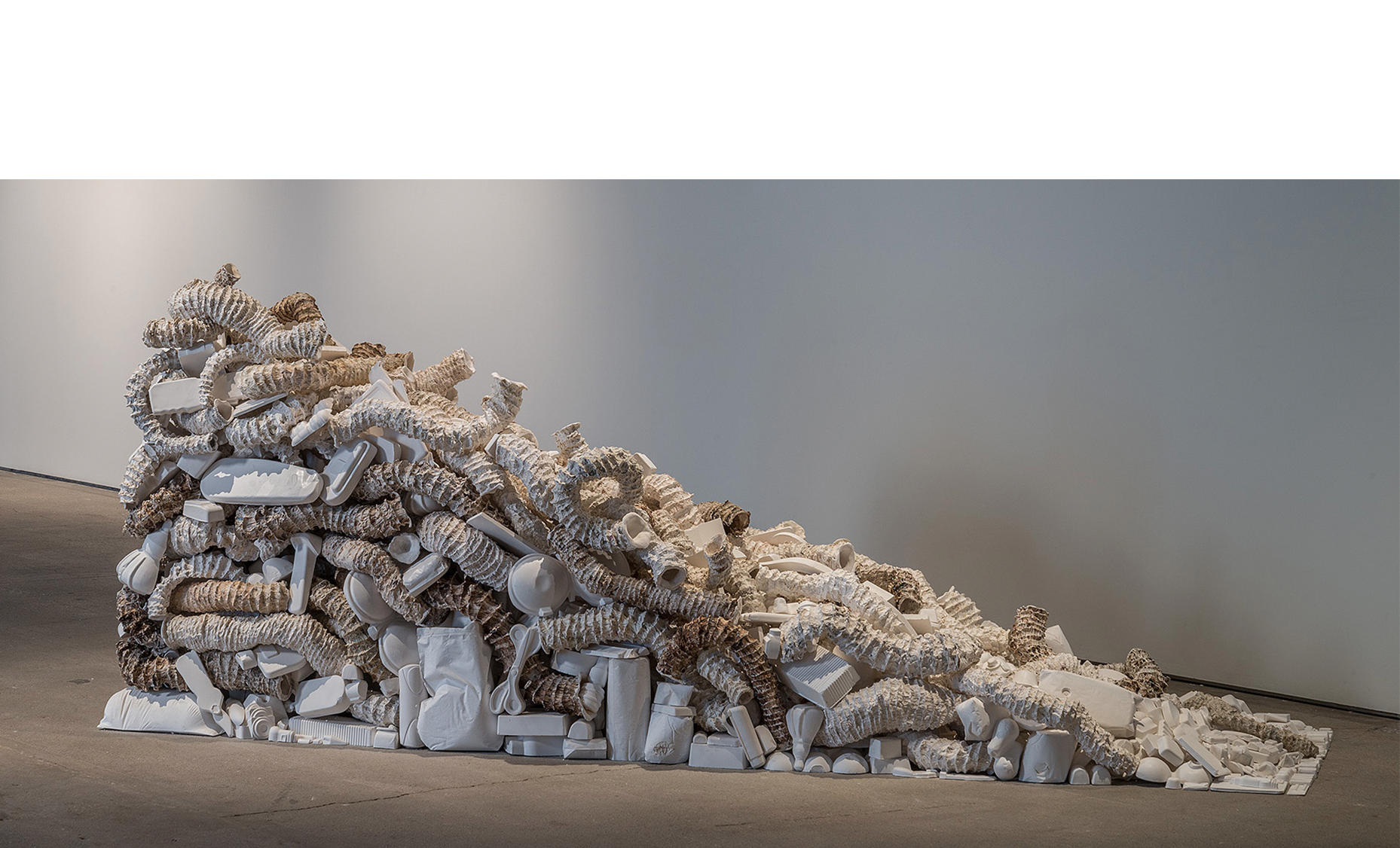 Seemingly Unconnected Events: The Wedge 2007- 2015 Hundreds of plaster casts of organic forms interwoven and interconnected with consumer goods casts*, 90 x 30 x 45”. Installation at H&R Block Artspace, Kansas City, MO, Fall 2015.
Photo: E.G. Schempf