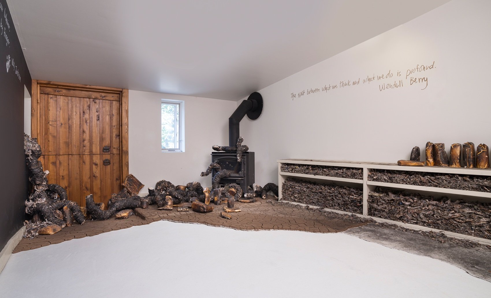   Seemingly Unconnected Events: The Writing is on the Wall/Heat, Drought &amp; Fire Gallery ,  2017, The Land Institute, Salina, Kansas.  Charred newspaper and cast plaster organic forms with charred consumer goods casts, cracked earth, ash, charred 