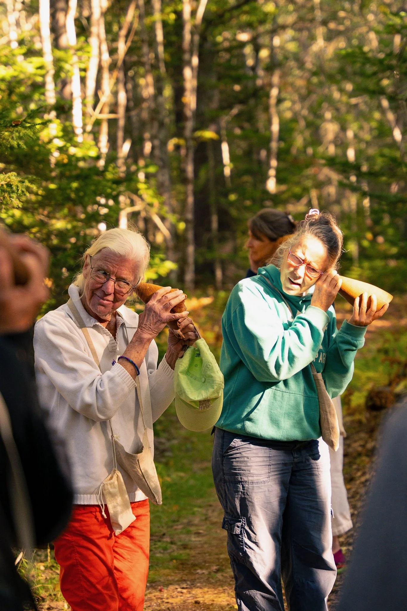  Participants listening to insects in boggy area with carved wooden burl listening horns 