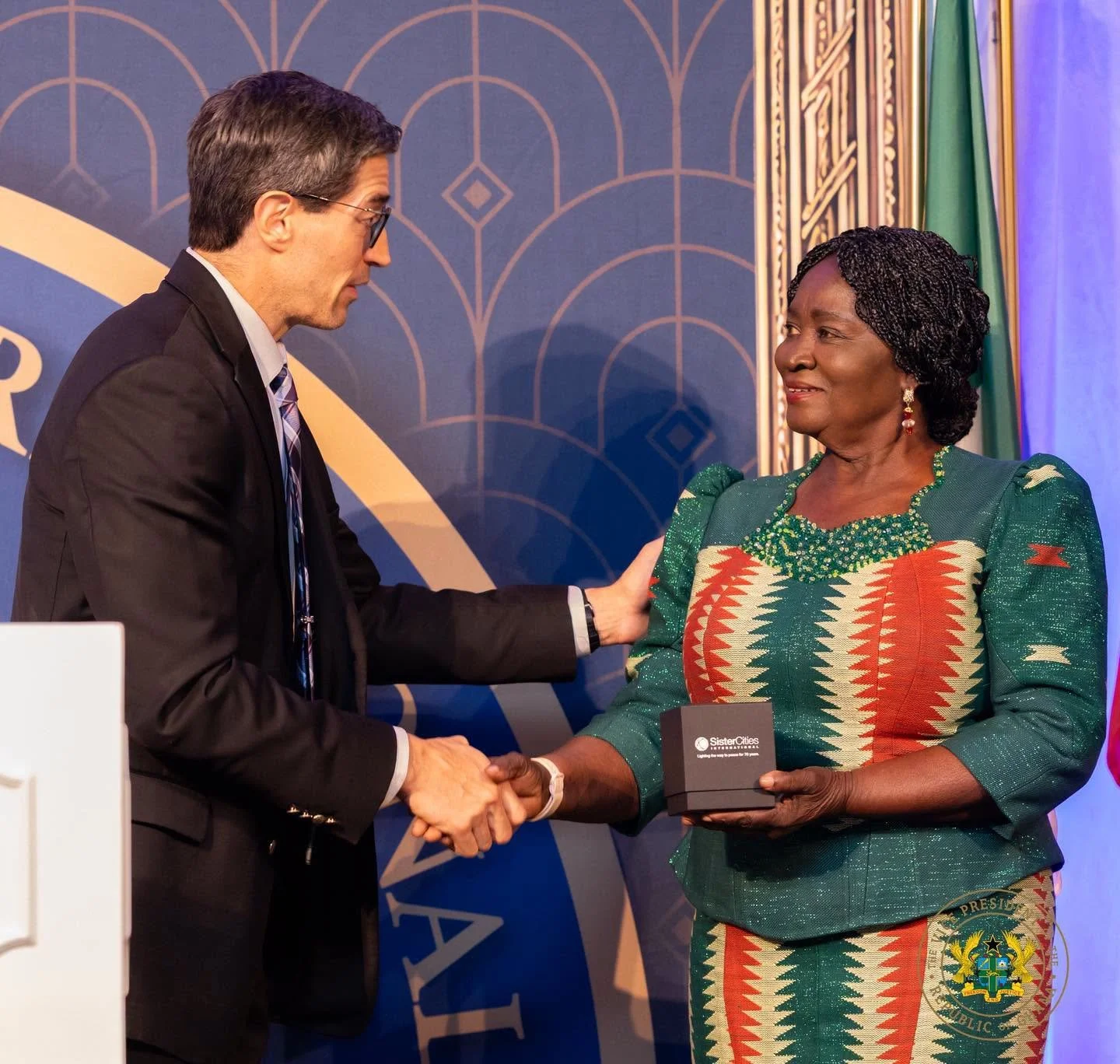 Carlo Capua shakes hands with Ghana Vice President Jane Naana Opoku-Agyemang as she holds a Sister Cities International commemorative gift.