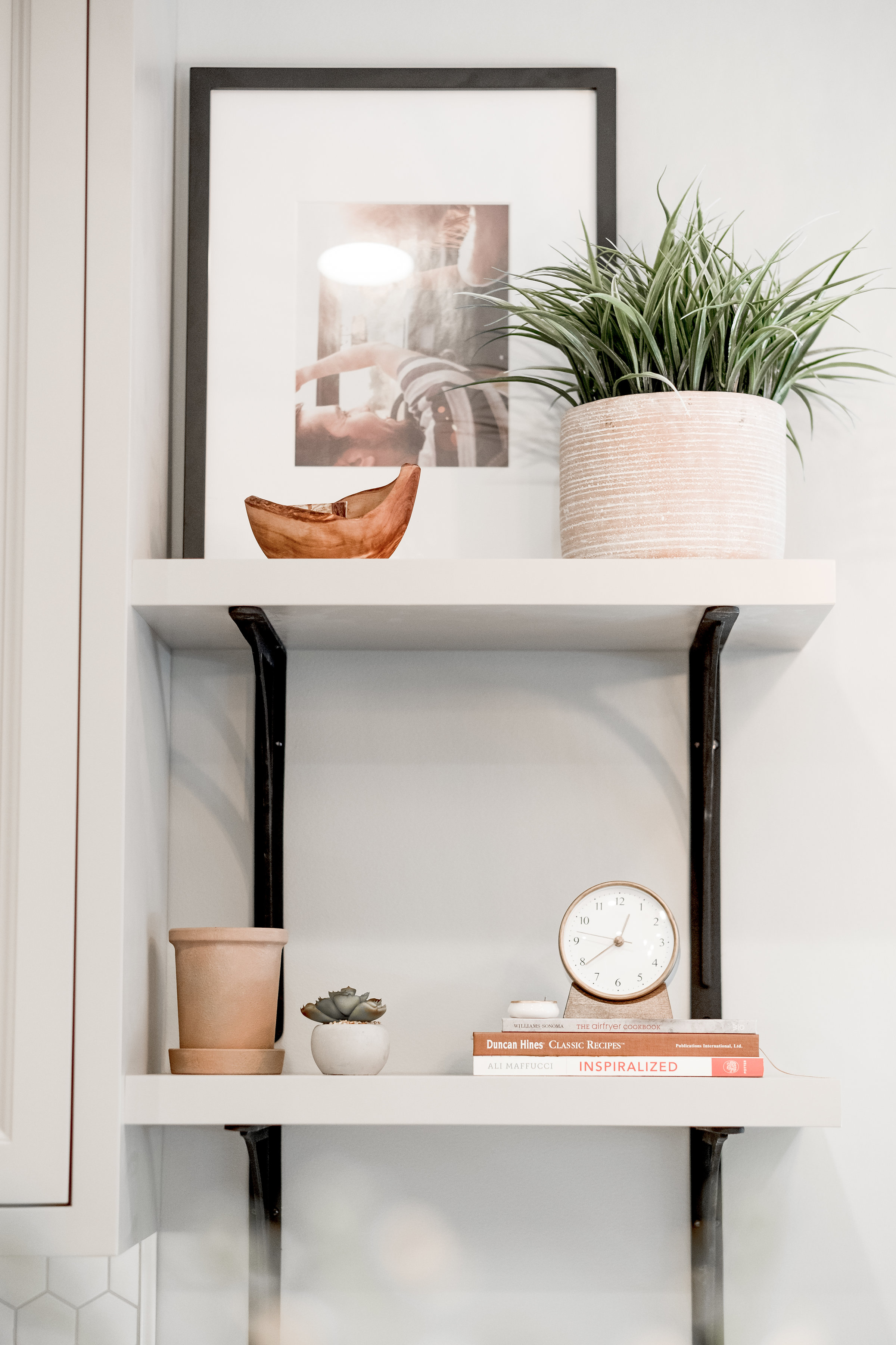 Open shelving styled with books, plants and art