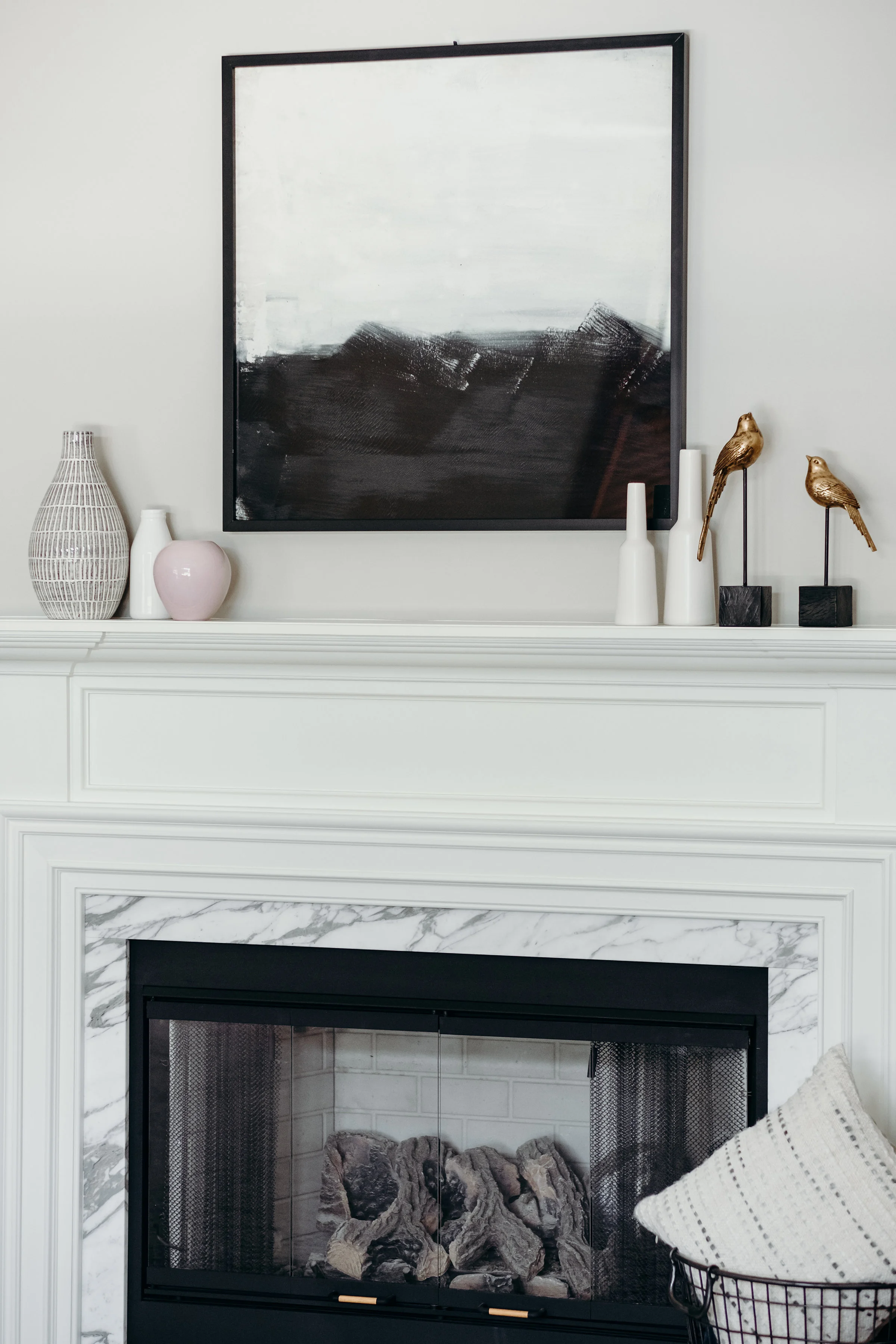Fireplace mantle with ceramic vases and large framed painting