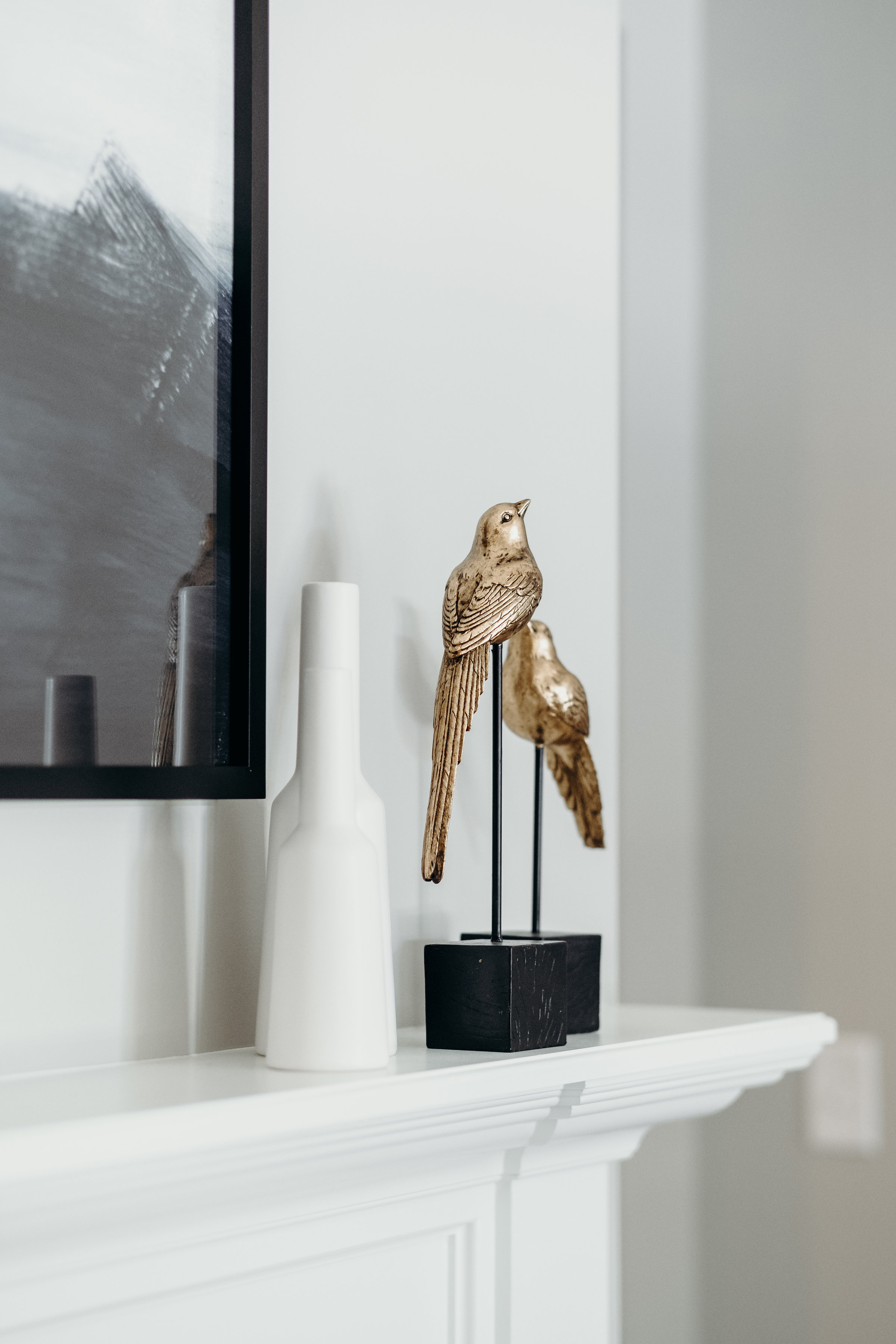Gold bird statues on fireplace mantle