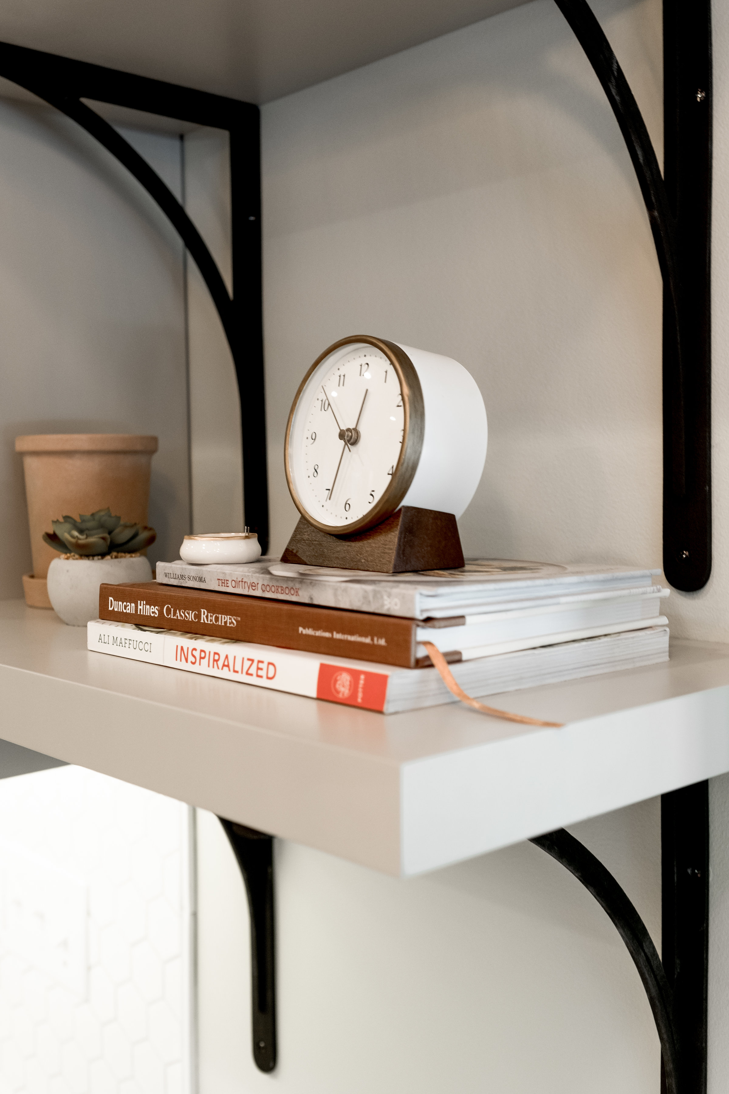 Open shelves styled with books and small clock