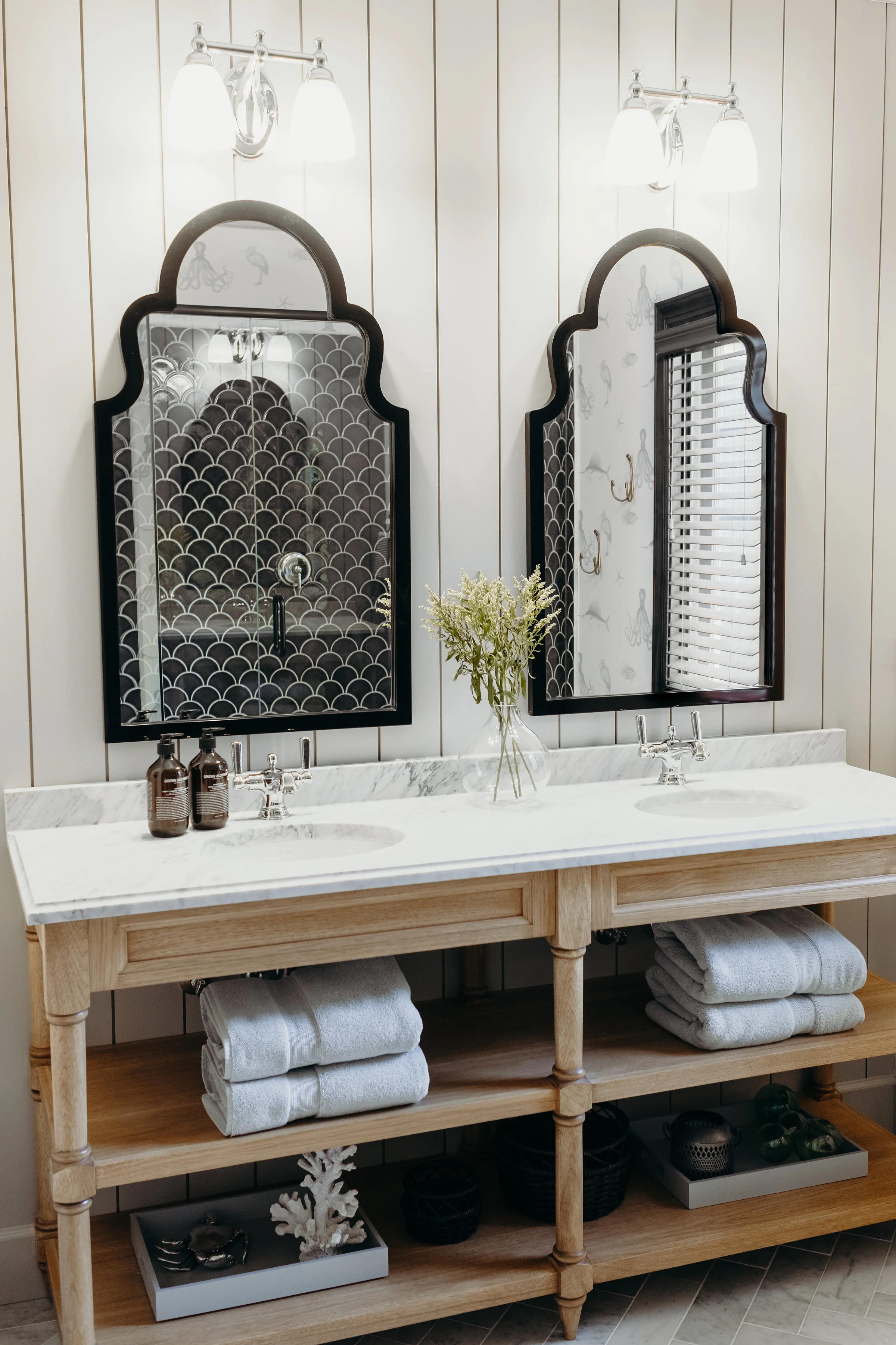 Wood vanity with open shelves, white stone countertops and vintage style mirrors