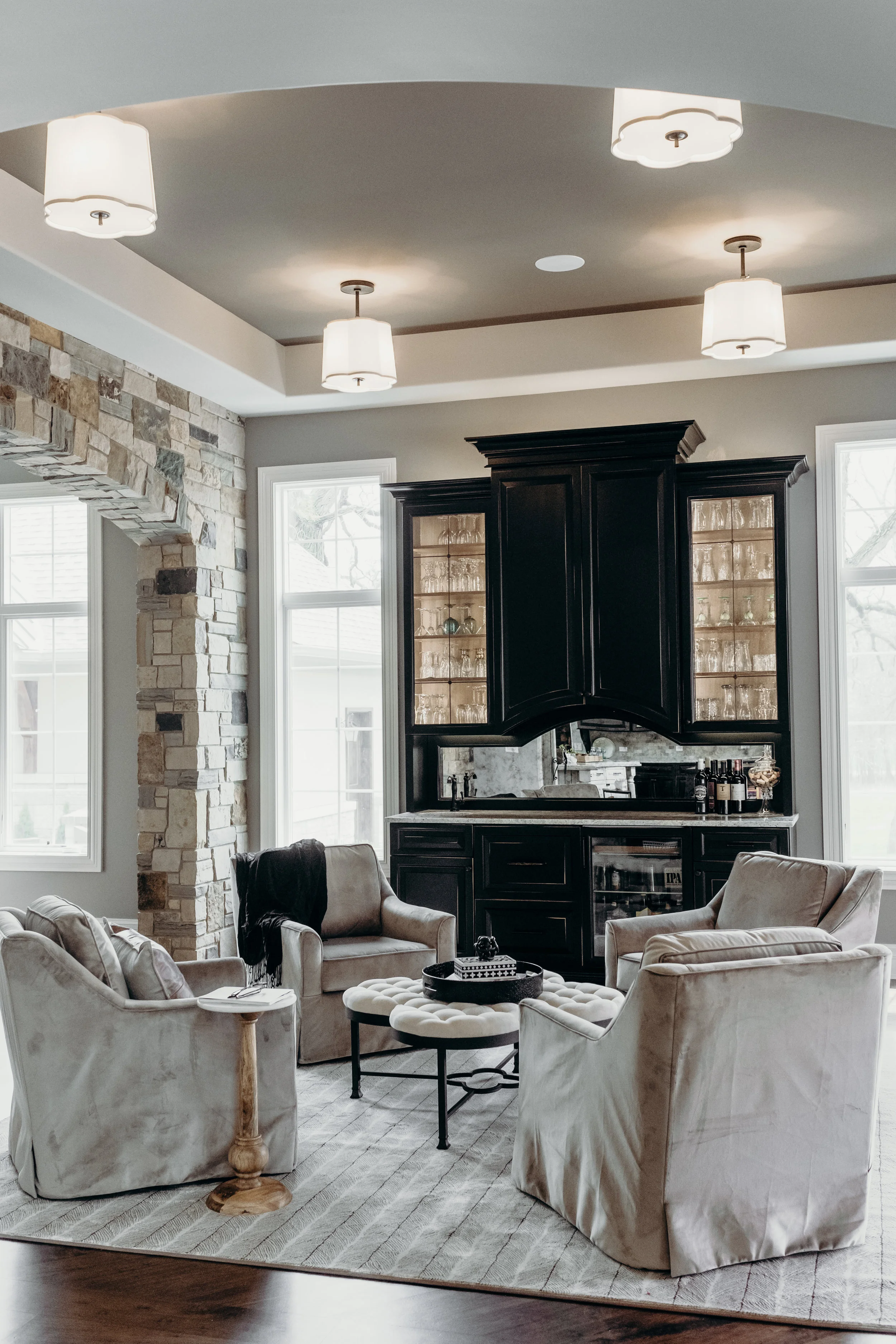 Lounge room with velvet swivel chairs, dark cabinets, and semi-flush mount lighting.
