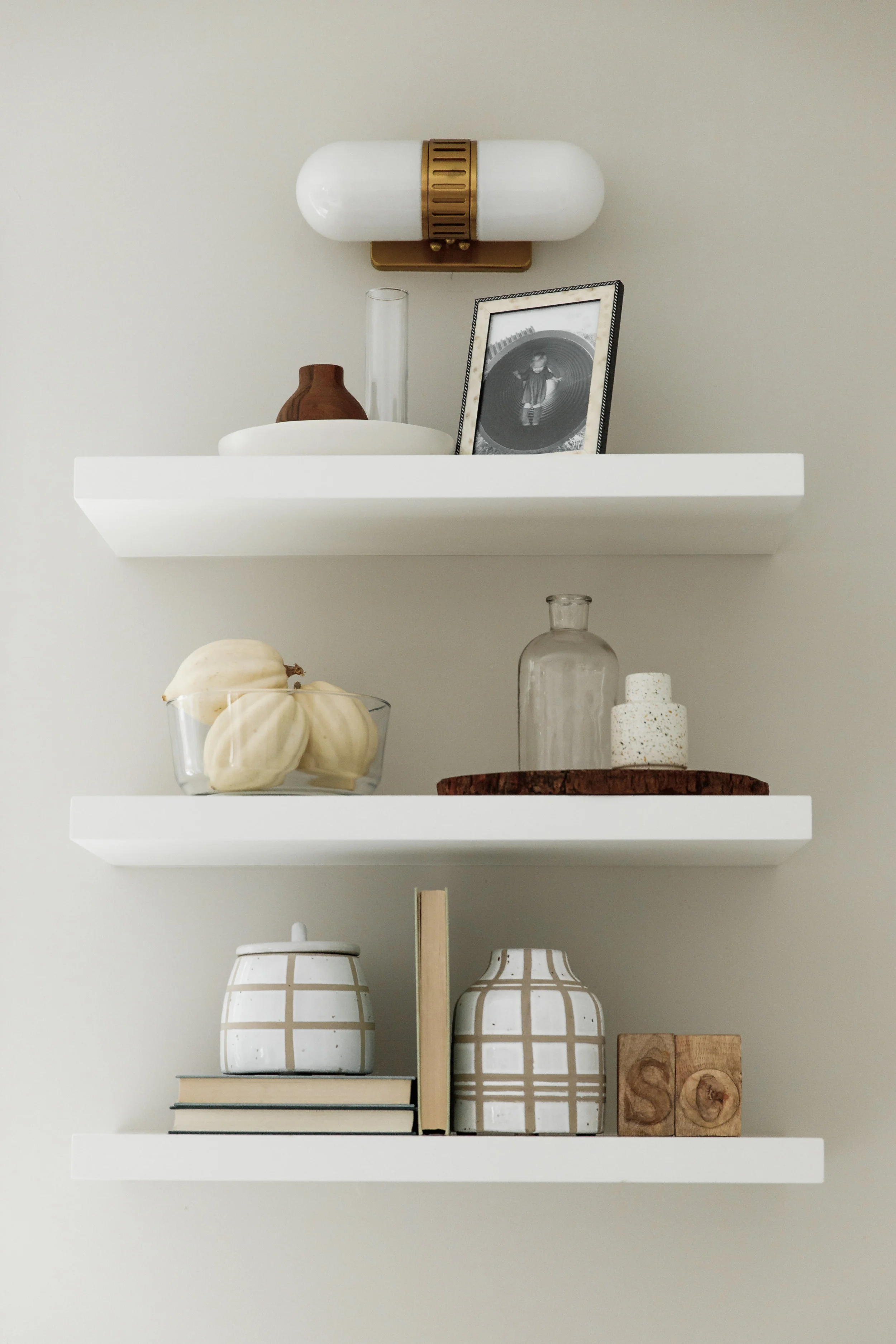White kitchen with brass hardware and oak floors | shelf styling
