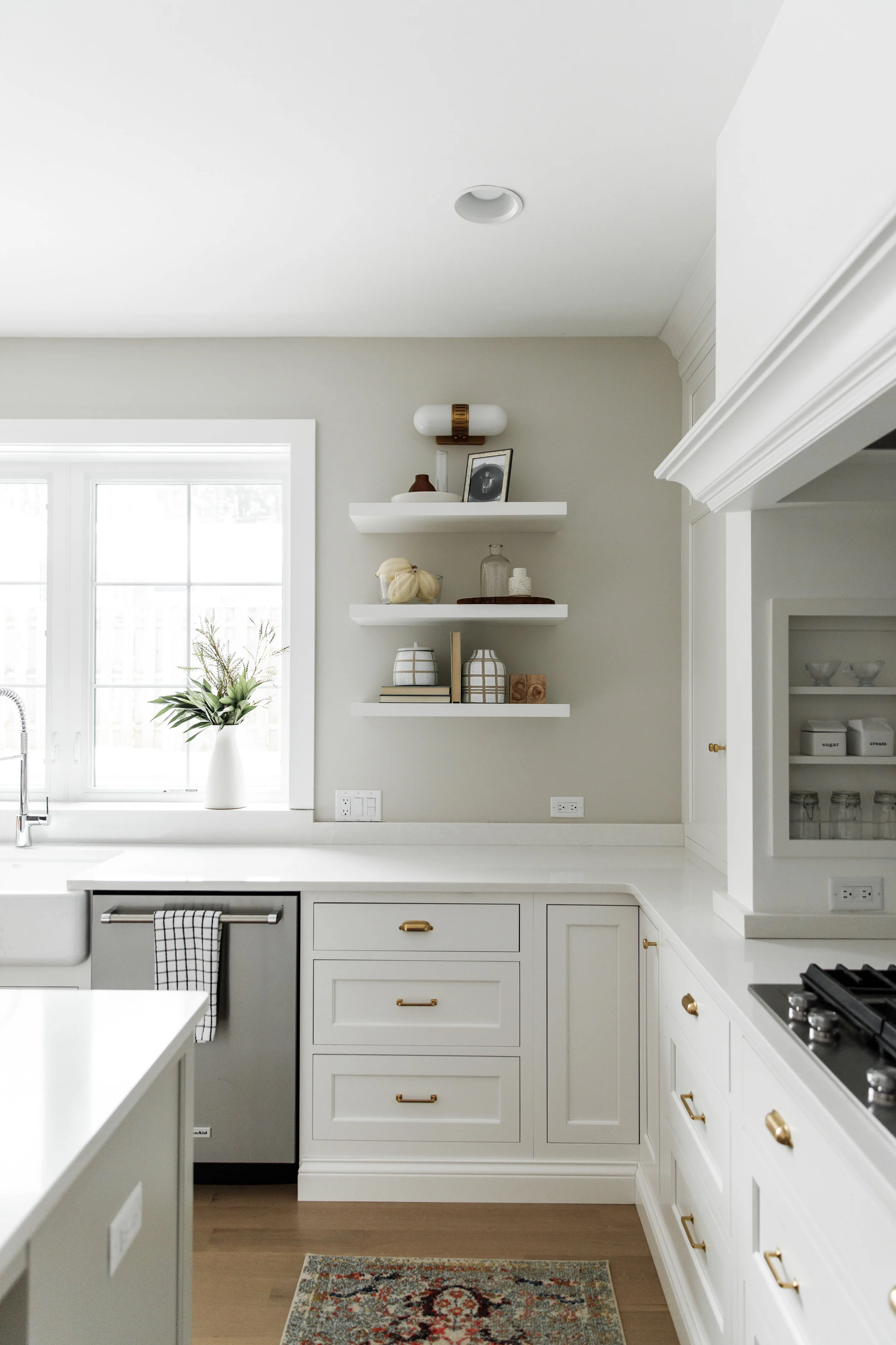 White kitchen with brass hardware and oak floors