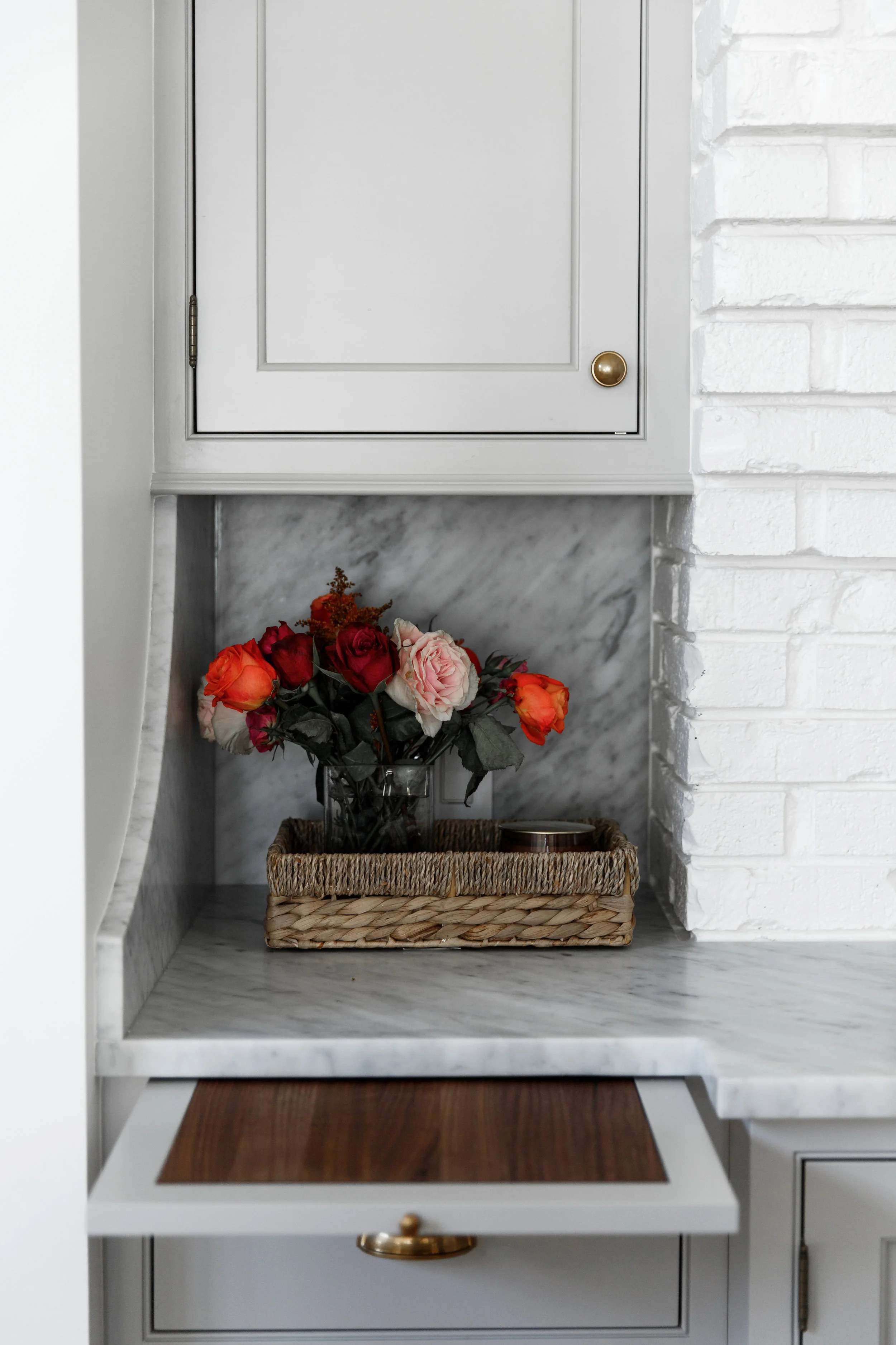 Kitchen cabinets with cutting board and marble backsplash