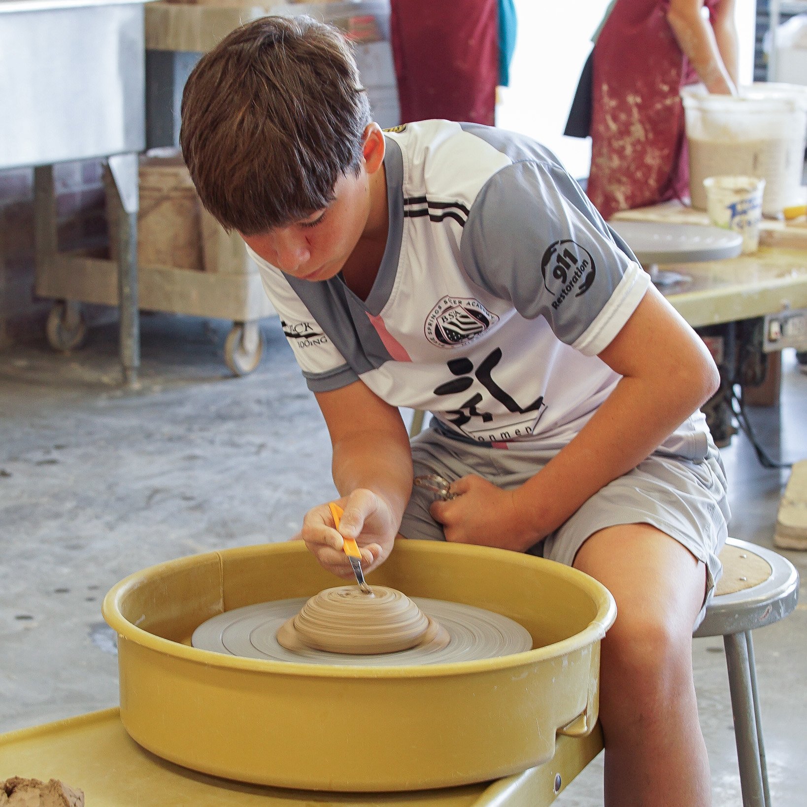 SQUARE_Kids Camp Week 1 2026_Kid wheel throwing.jpg