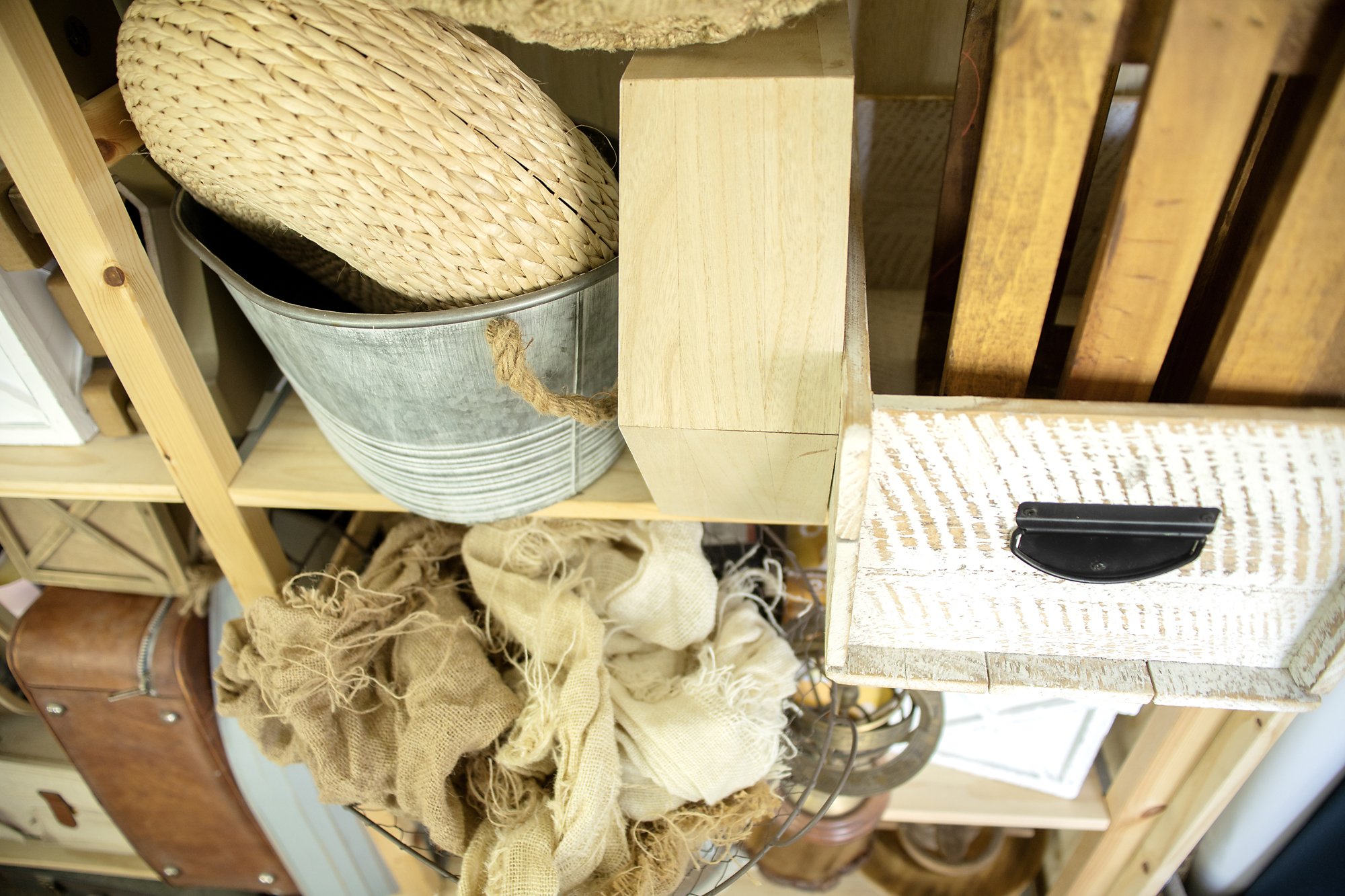 Jacksonville FL newborn photographer studio with wooden props on shelves and boutique buckets.
