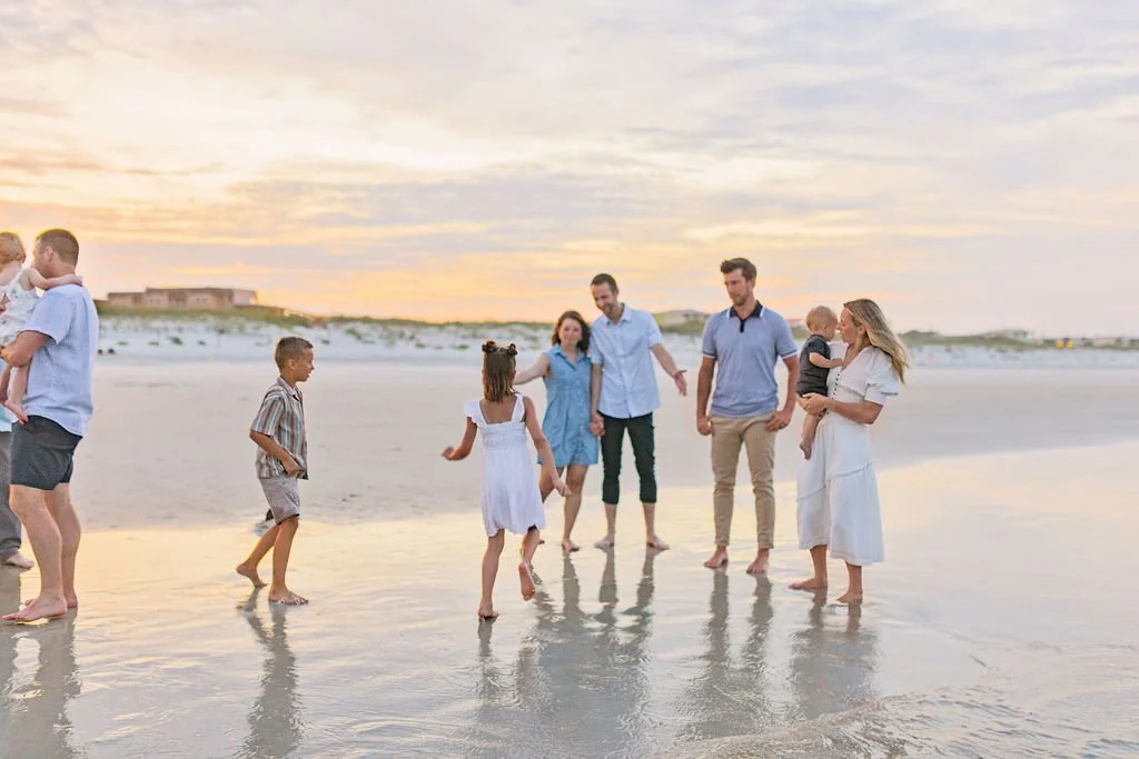 Beach family photo shoot at sunset with extended family reunion vacation on Crescent beach 32080 with people wearing coastal colors and beige or white pants and dresses
