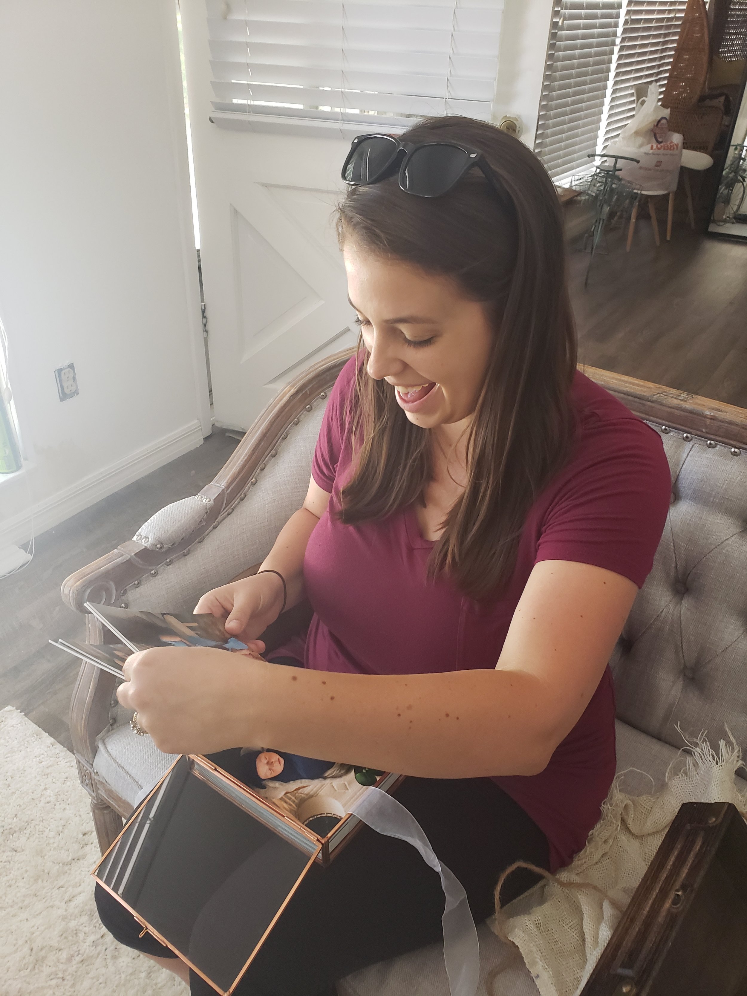 St. Augustine FL maternity photographer in luxury studio with pregnant mom looking at simple, modern baby bump photos.