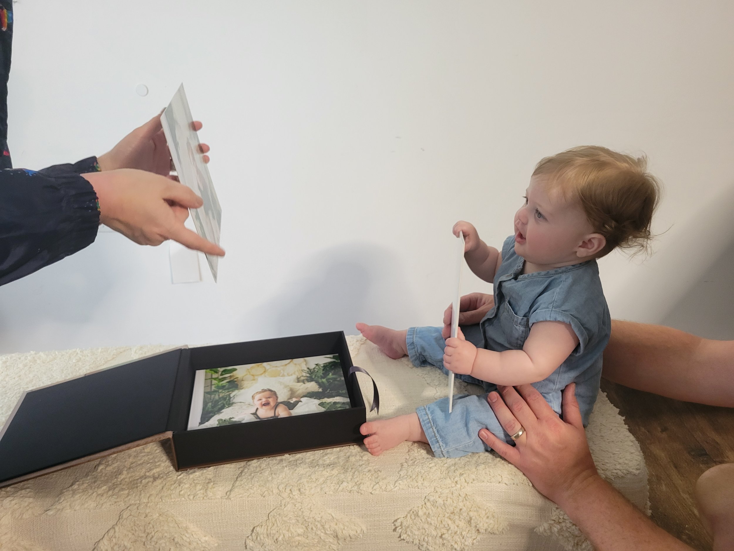 6 month old baby girl looking at milestone session photos in Palm Coast, FL.
