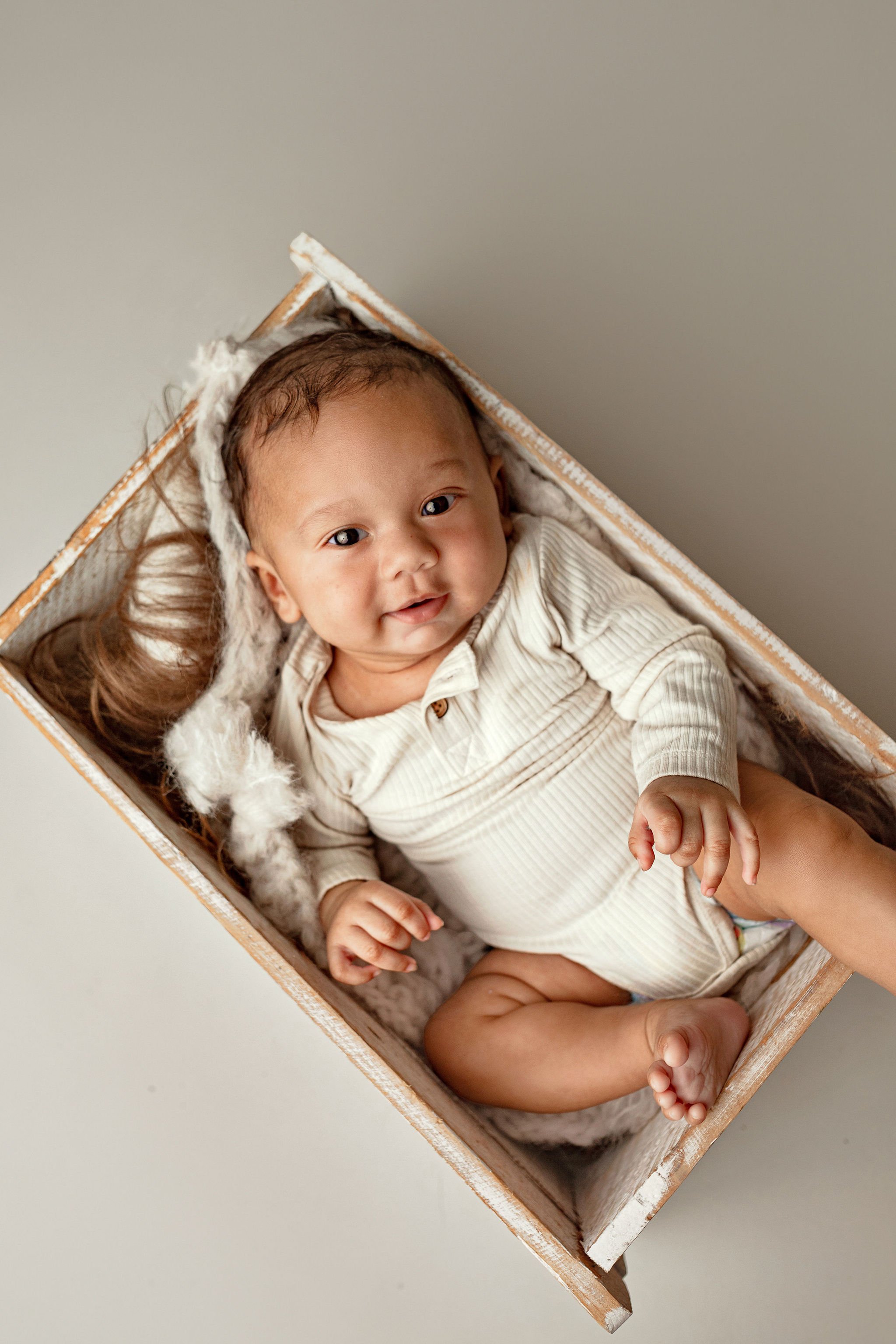 Milestone photo shoot with 6 month old baby boy from african american family with neutral clothes and background and no props in Palm Coast, FL
