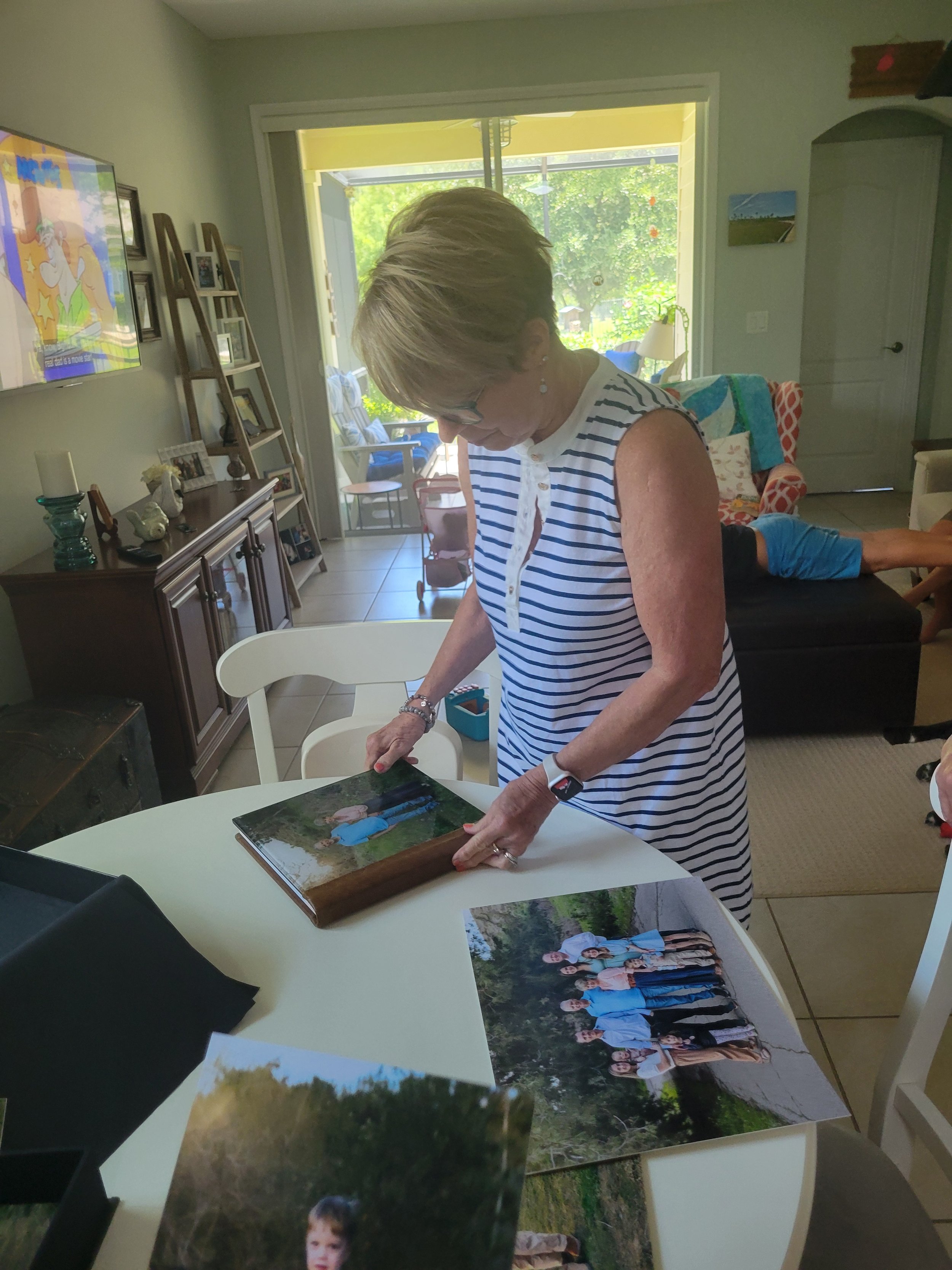 Grandmother looking at wall art for vacation family photo session in Saint Aug, FL enjoying natural light of outdoor photography.