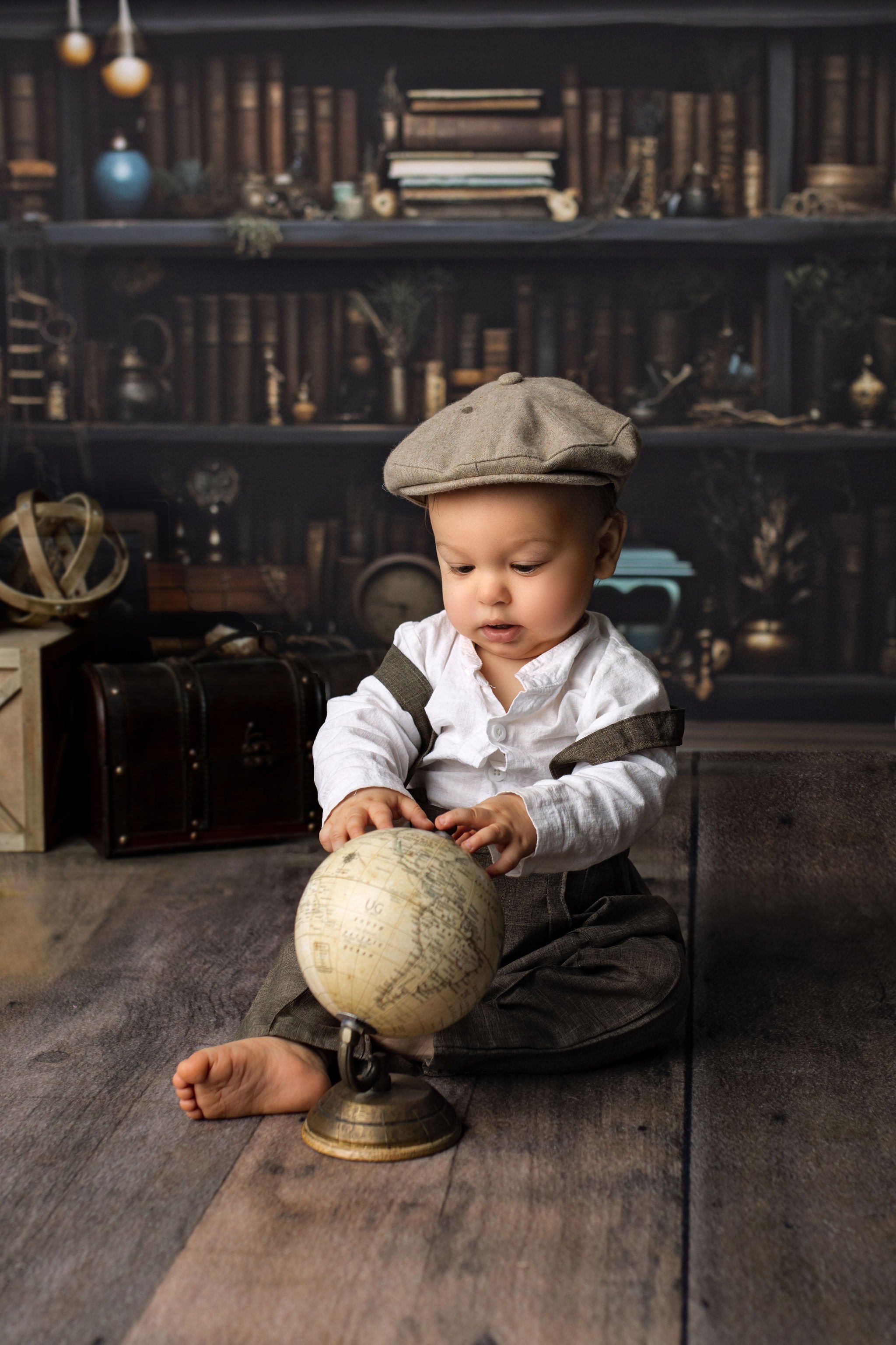 Best cake smash photographer in Jacksonville Beach, FL with vintage themed milestone session and globe with books for one year old boy