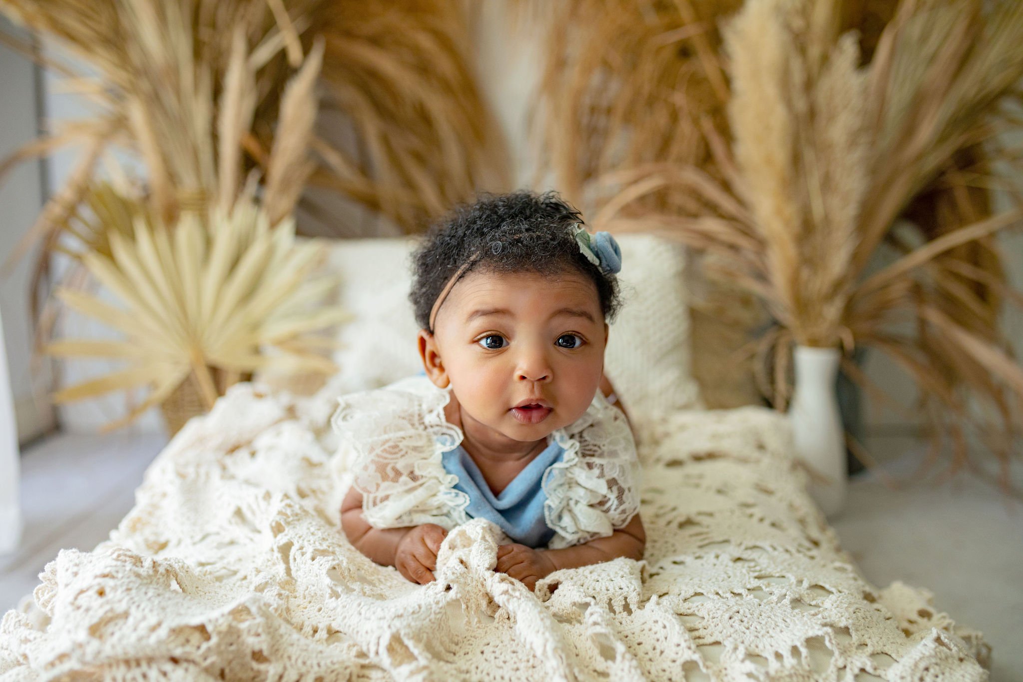 Natural light photography in Ponte Vedra photo studio for 6 month old milestone birthday for baby in white lace, boho vibes, and minimal props