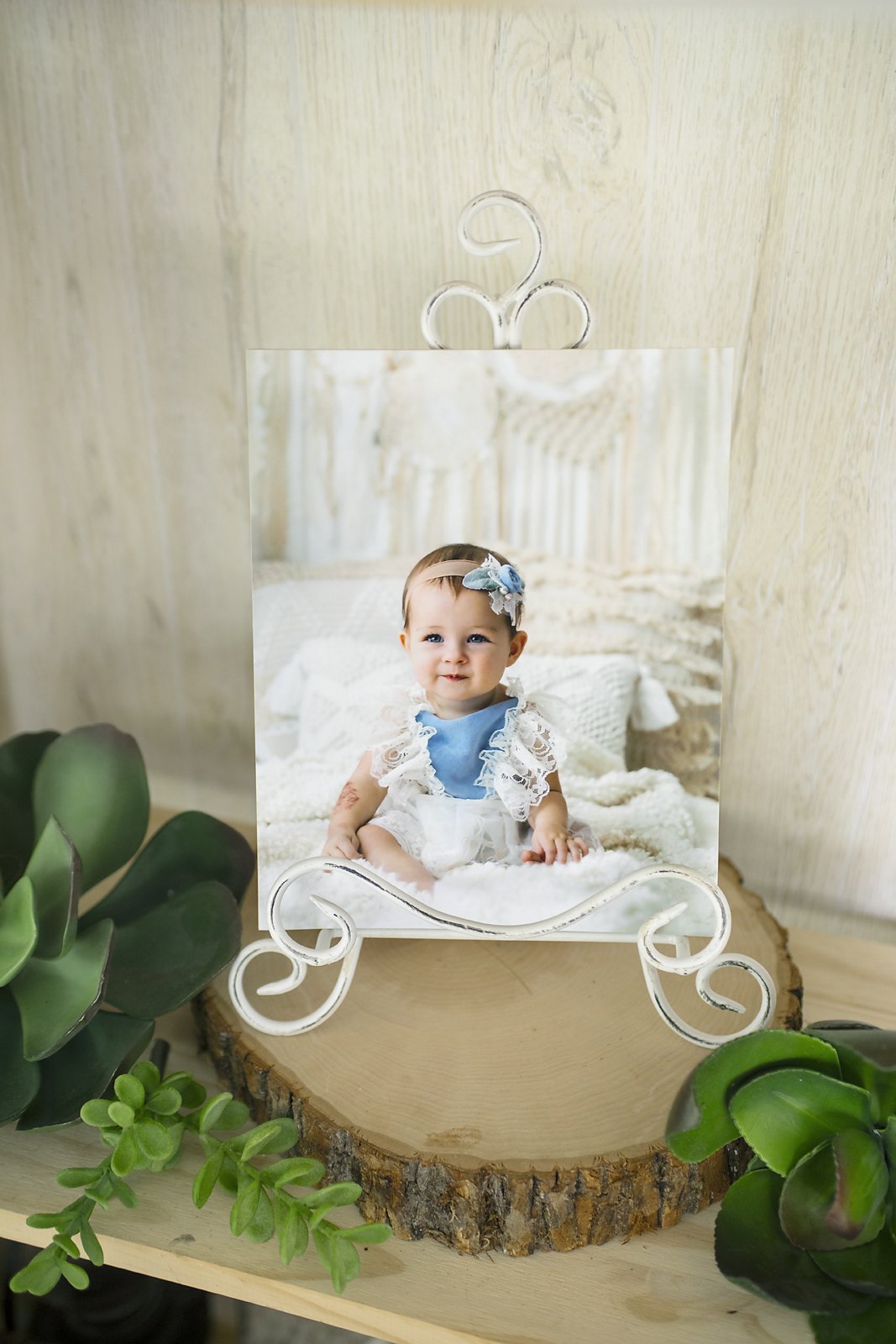 Framed photo of a milestone photo shoot with 6 month old baby in hand made vintage dress and heirloom props in luxury portrait studio located in Ponte Vedra Beach, Florida.