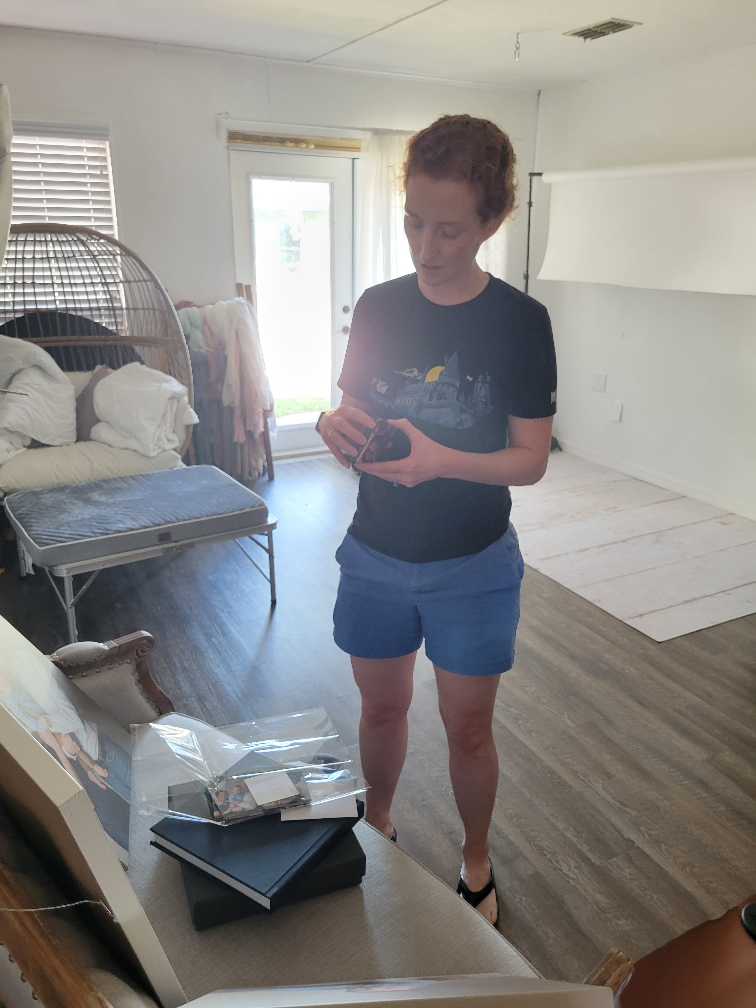 Engineer mom in Jacksonville photo studio looking at pictures of newborn baby with high end props and classic, timeless style.