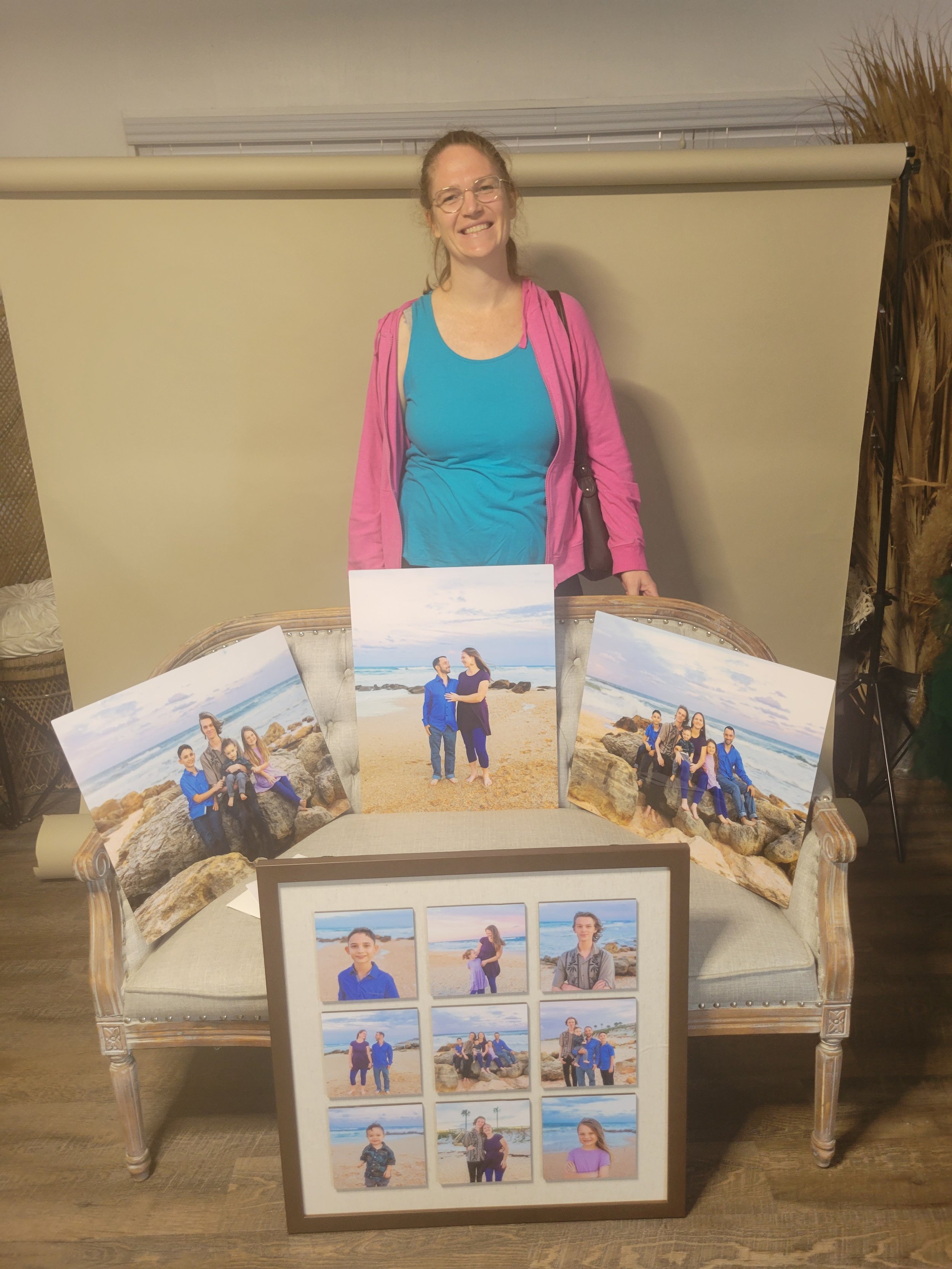 JAX Beach, FL mom stands with wall art collage and pictures from family photo shoot at the beach with best JAX photographer for families.