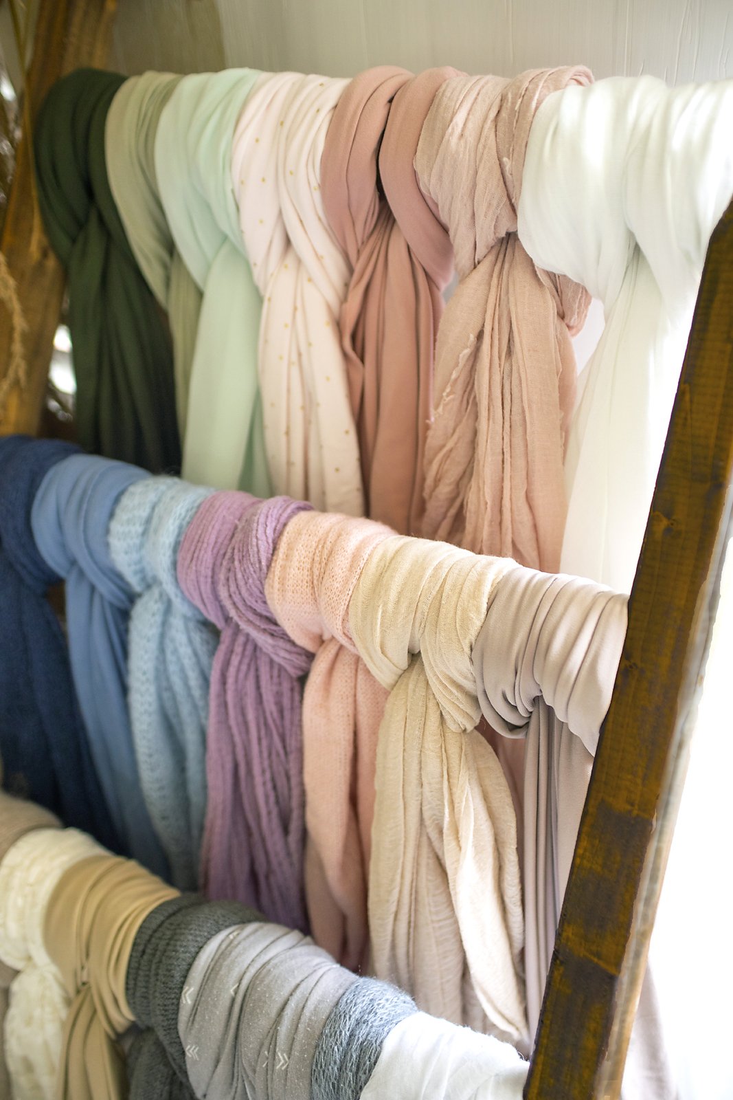 Boutique props and earth tone and pastel colored wraps for newborn session in high end Ponte Vedra photography studio