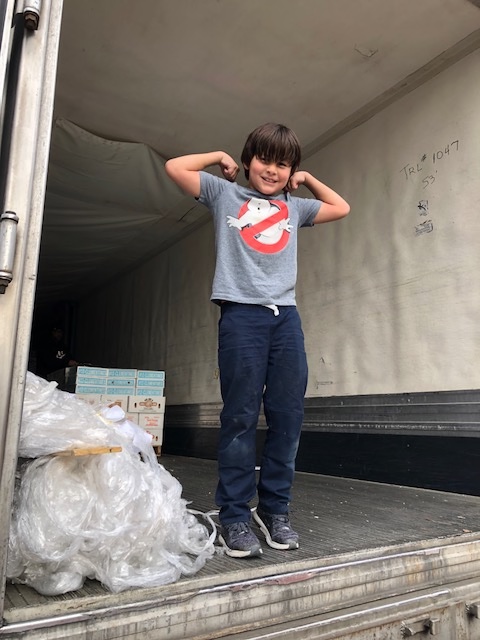 Grayson Moody, son of the Fruit Sale Chair, helping the Rowing Club unload the truck.