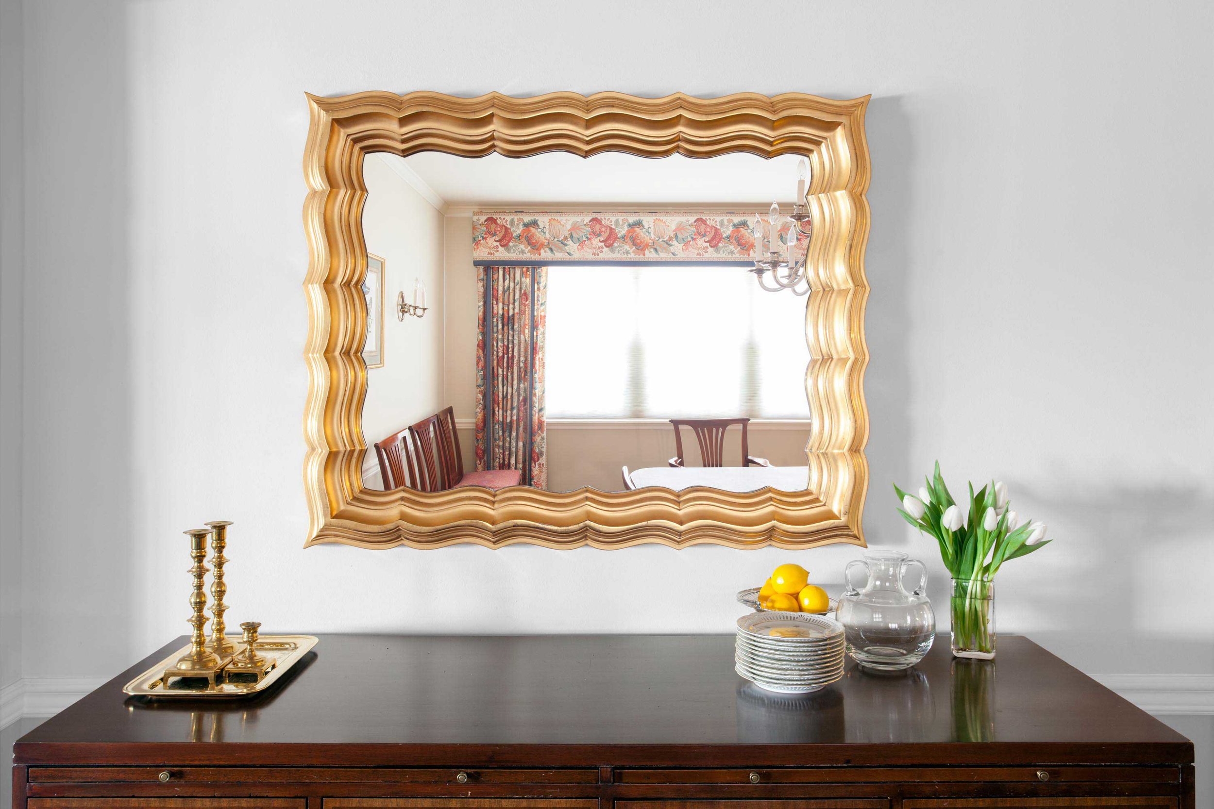 Decorative gold framed TV mirror handing over wooden console table