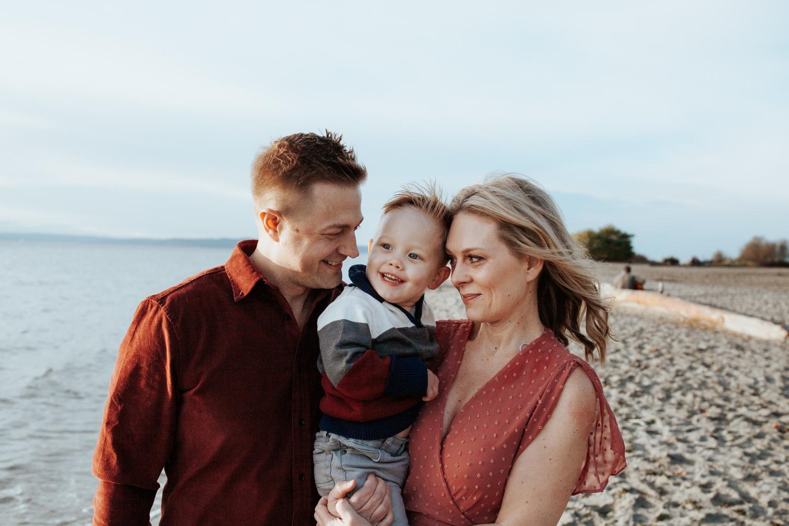  A family in red plays together on the beach for lifestyle mini sessions at Golden Gardens in Seattle.&nbsp; 