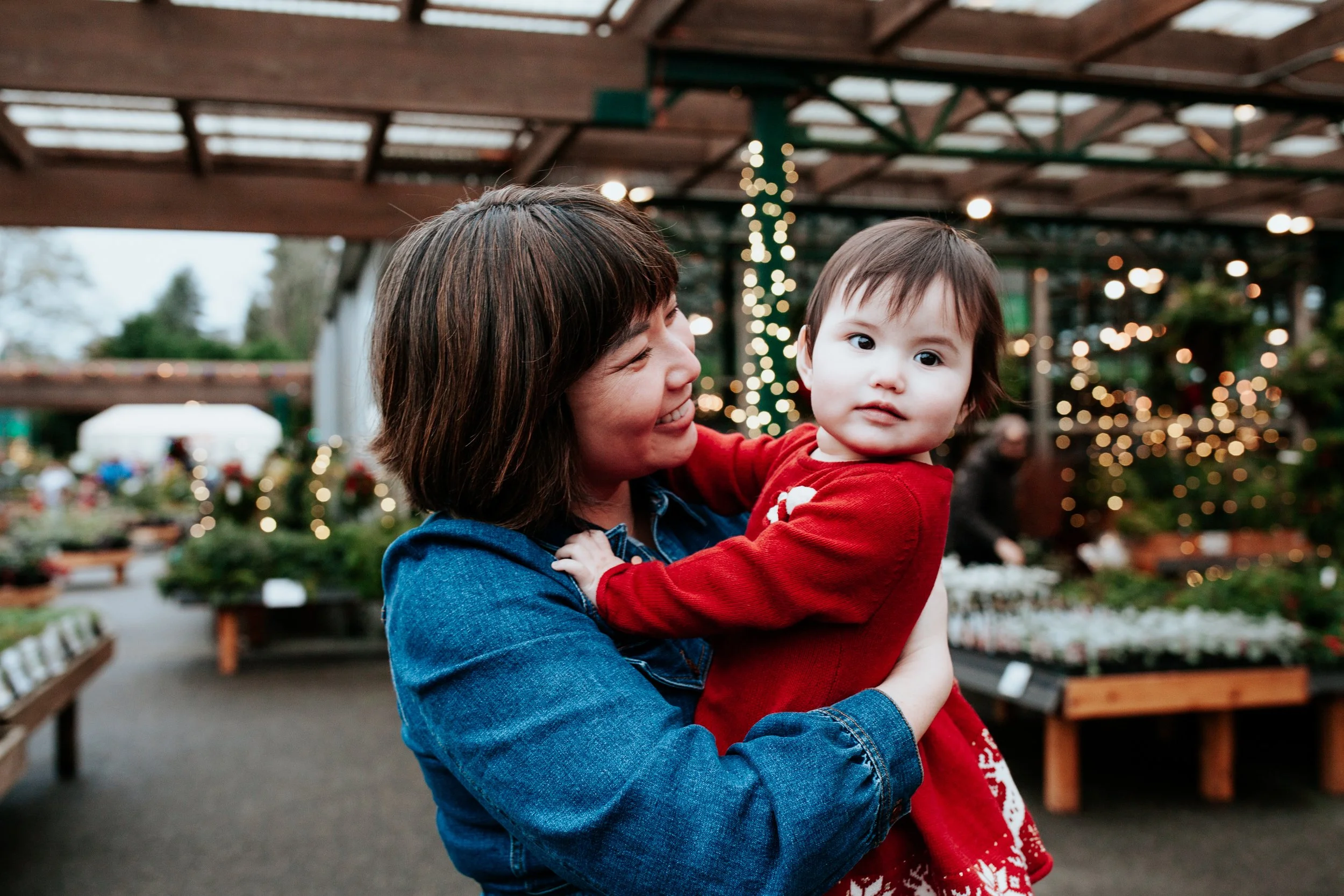 a mom smiles at her baby girl at swansons for holiday mini sessions in seattle