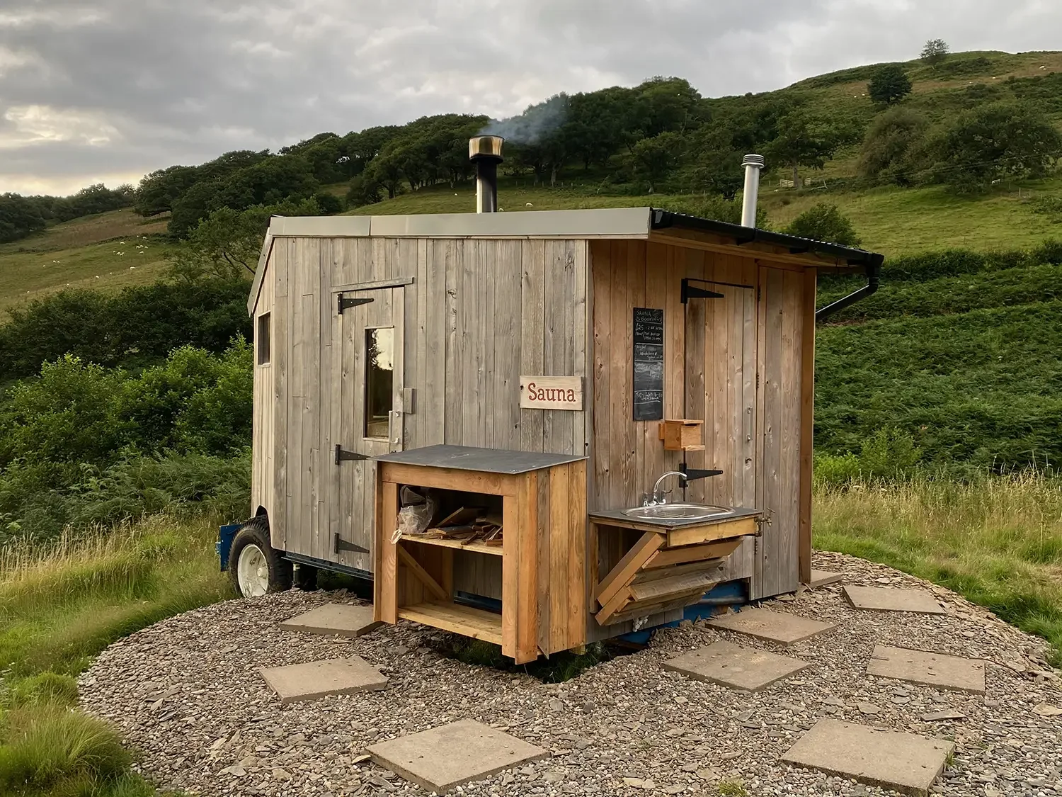 Quirky timber clad outdoor sauna in an outdoor location in rolling hills of mid Wales, UK.