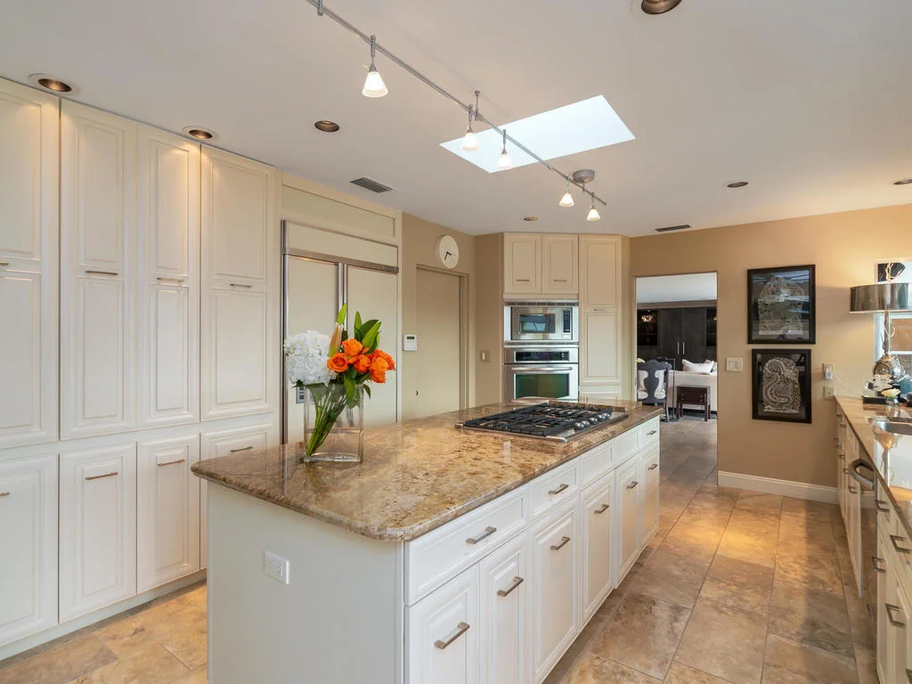 The light and bright kitchen features stainless appliances, 6-burner gas stove on cooking island, solid wood cabinetry, beautiful neutral granite, and sliding pull-out shelving in every cabinet (including under the sink! No more rummaging for cleaning supplies.)