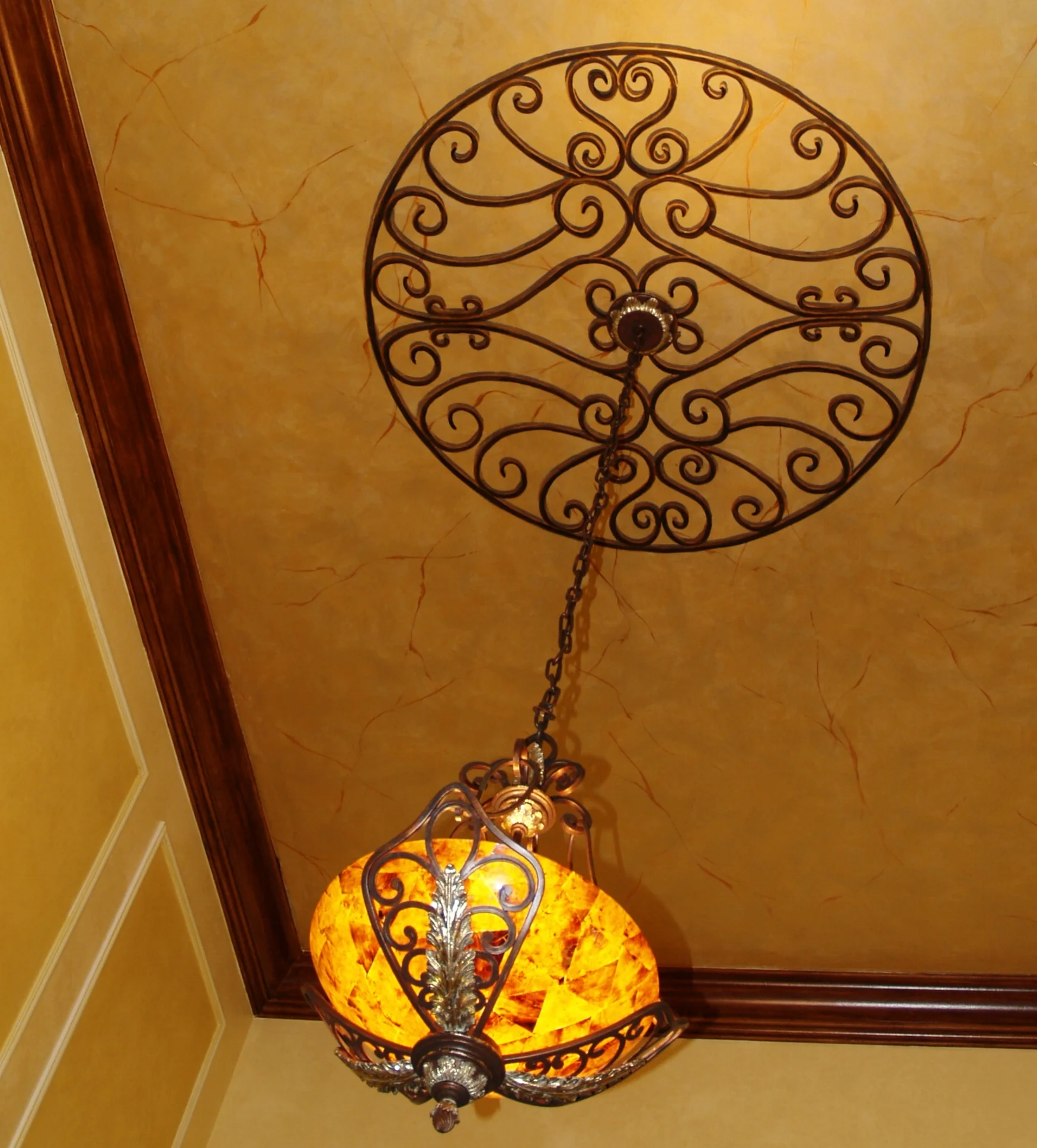  The entire area including the walls, trim, and ceiling are done in a faux finish. The walls in done in yellow, the trim done in a rich wood finish, and the ceiling was hand painted gold with veining run through it. Finally the medallion was hand pai
