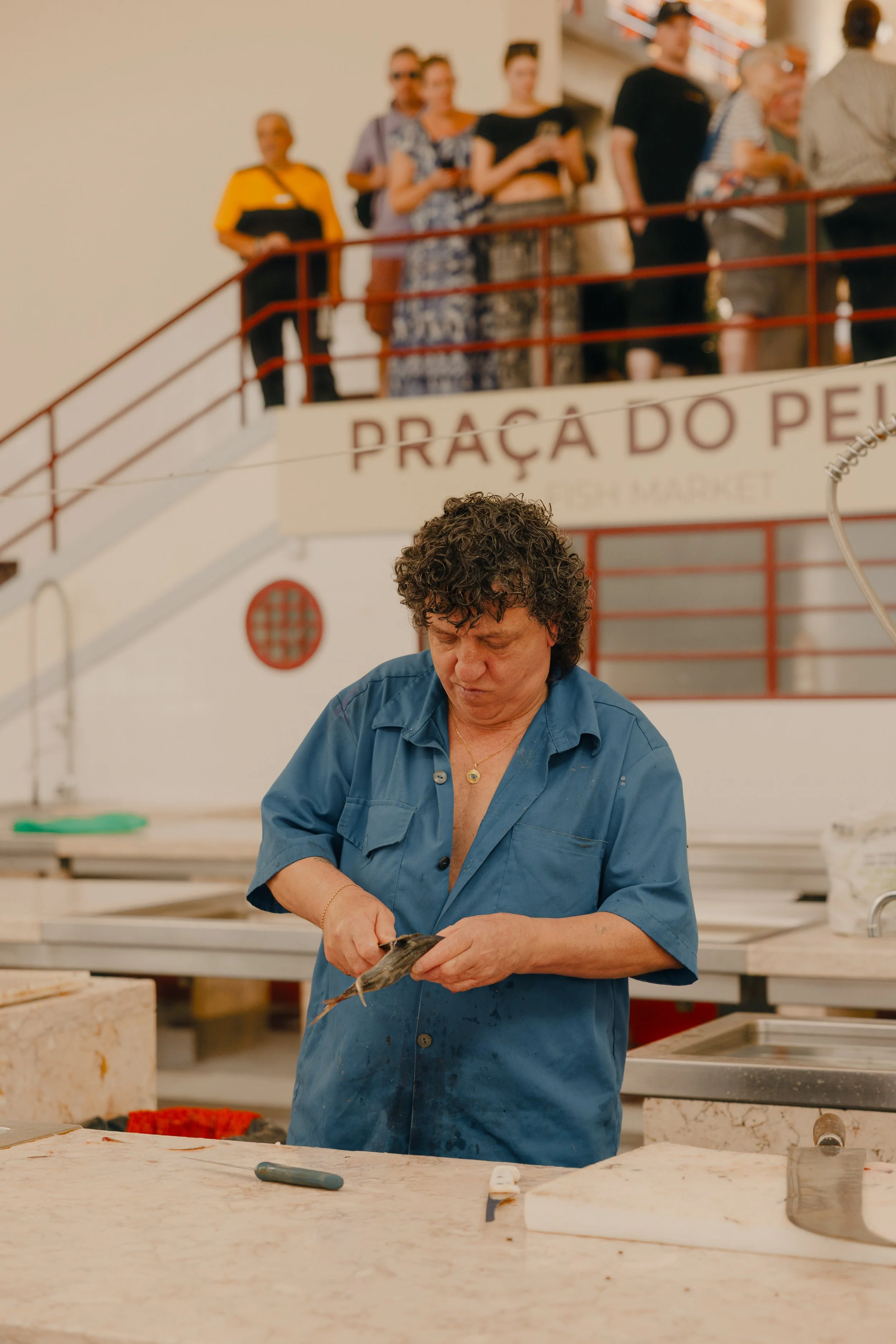 A fishmonger gutting a fish at the Mercado dos Lavradores in Funchal, Madeira