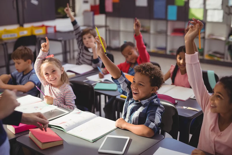 Schoolkids_raising_their_hands_in_classroom (1).jpg