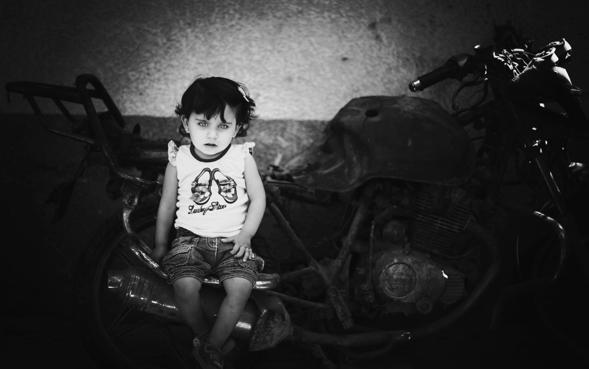 "My two sons and my precious grandson turned into ashes" Islam's grandfather. Islam Qreqe ,14 months old, sitting on a burned motorcycle where three of her family members were targeted, bombed, and killed by a rocket fired from an Israeli aircraft drone. Islam's father, Moataz Qreqe, was riding this motorcycle along with his two-year-old son and his brother (Munther Qreqe) when the cycle was hit during an airstrike at Jamal Abdul Nassesr Street in Gaza City. Their bodies were completely scorched. Four months later, Islam was born and named after her deceased two-year-old brother. © Images by Eman Mohammed | Broken Souvenirs series.