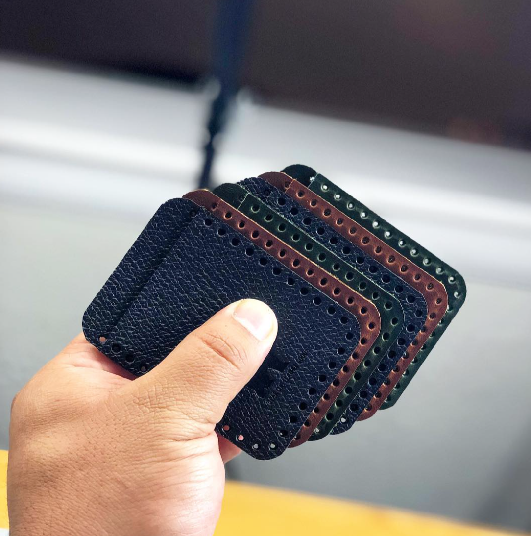Leather punched phone pockets in hand created by Bear Cub Leather Goods in Houston, Texas