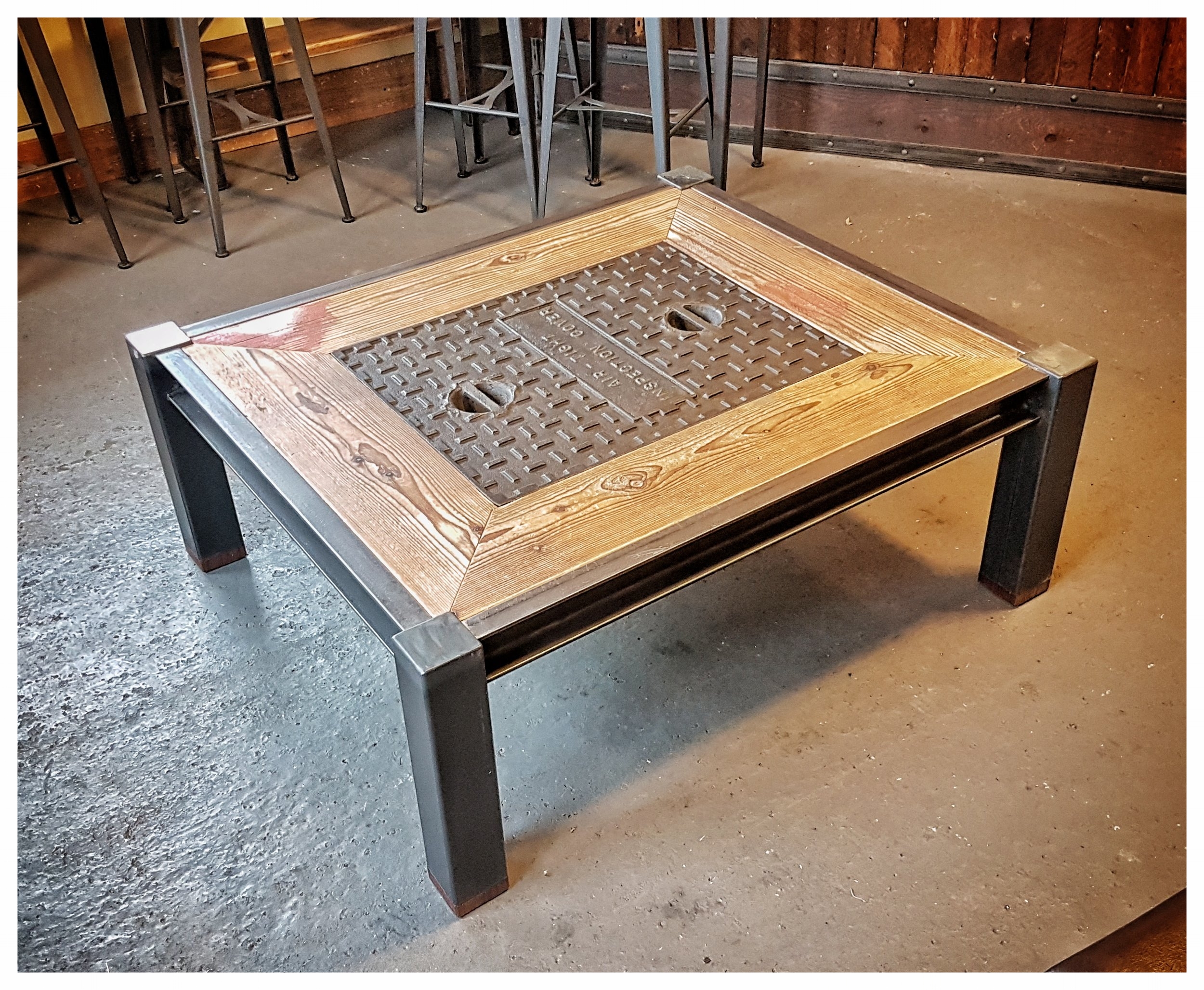 Up-cycled drain cover, wood inlay and steel frame coffee table. 