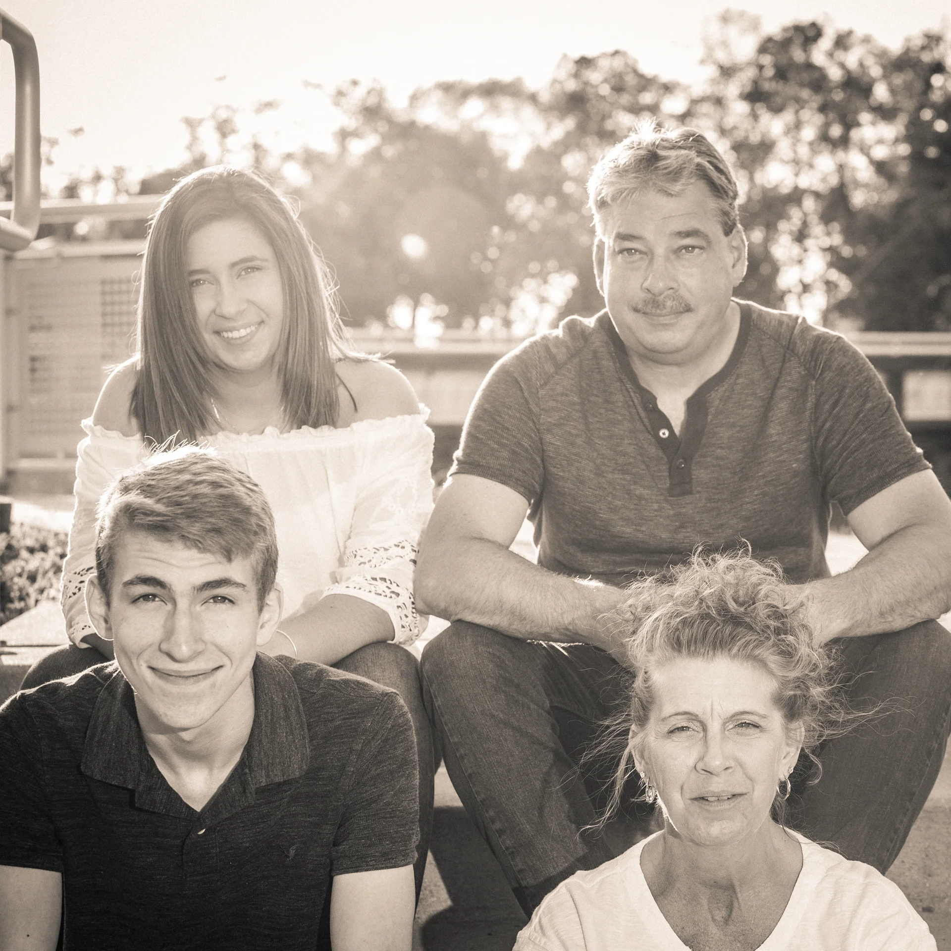 This image with the Kohler family casually sitting on some steps with the sun flare highlighting hem while I illuminated them with an off-camera speedlight is one of my favorites from the session. I decided to put a warm tone to the black and white version of the photo to give it a timeless feel.