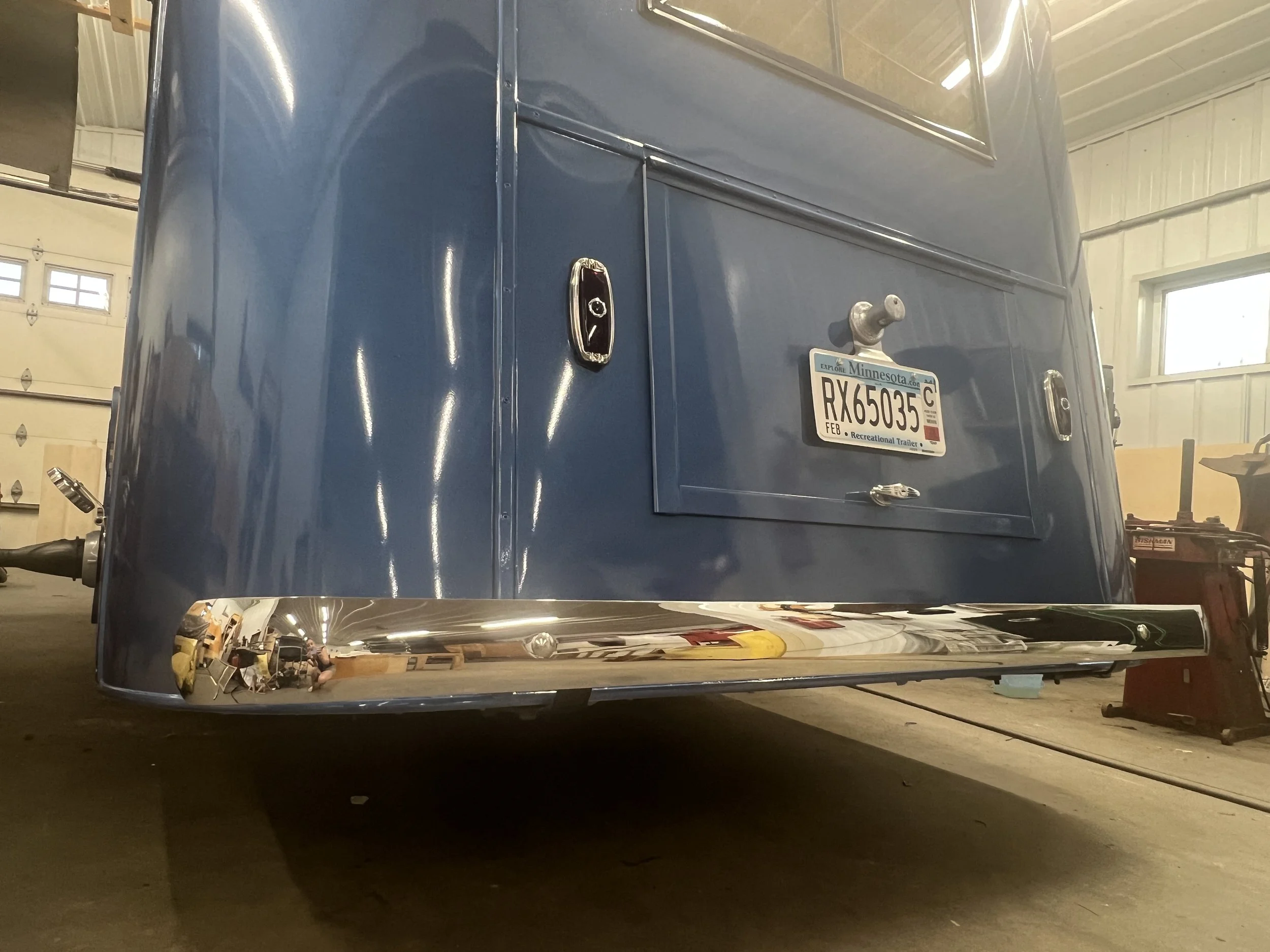 The final piece of the puzzle: the re-chromed bumper is installed