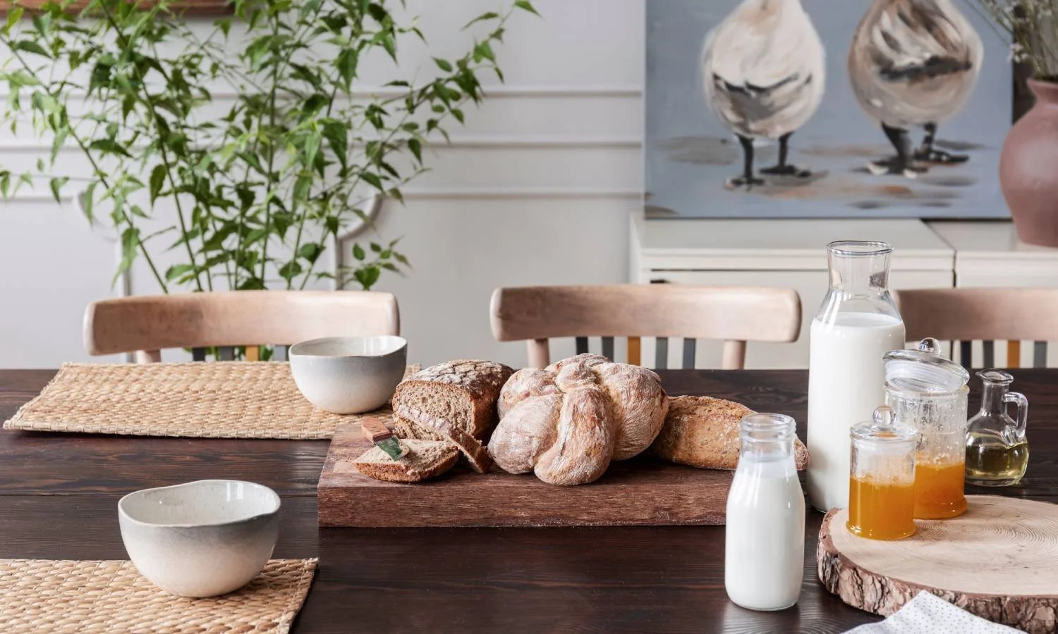 Cottagecore-inspired kitchen table that has honey and bread, and white walls in the background