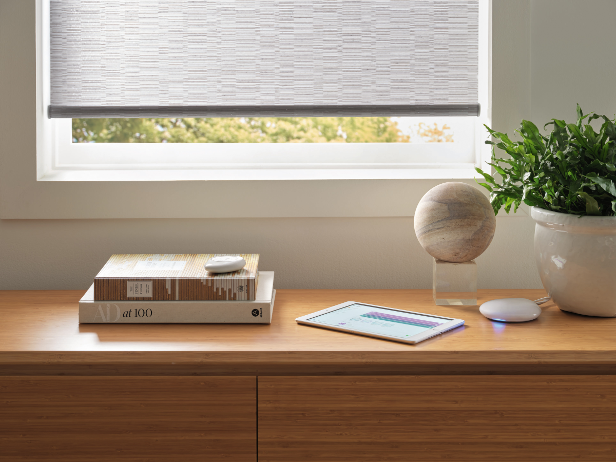 Hunter Douglas PowerView® Automation remote, app on a tablet, and Gateway system near motorized roller shades