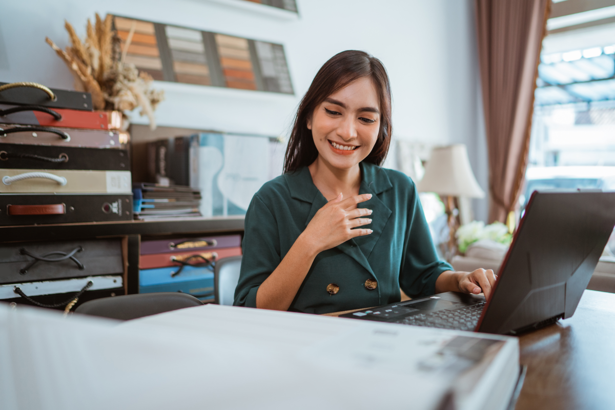A window treatment specialist with color and style samples around her, working on a client project