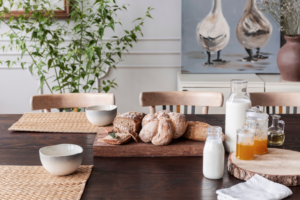 Cottagecore-inspired kitchen table that has honey and bread, and white walls in the background