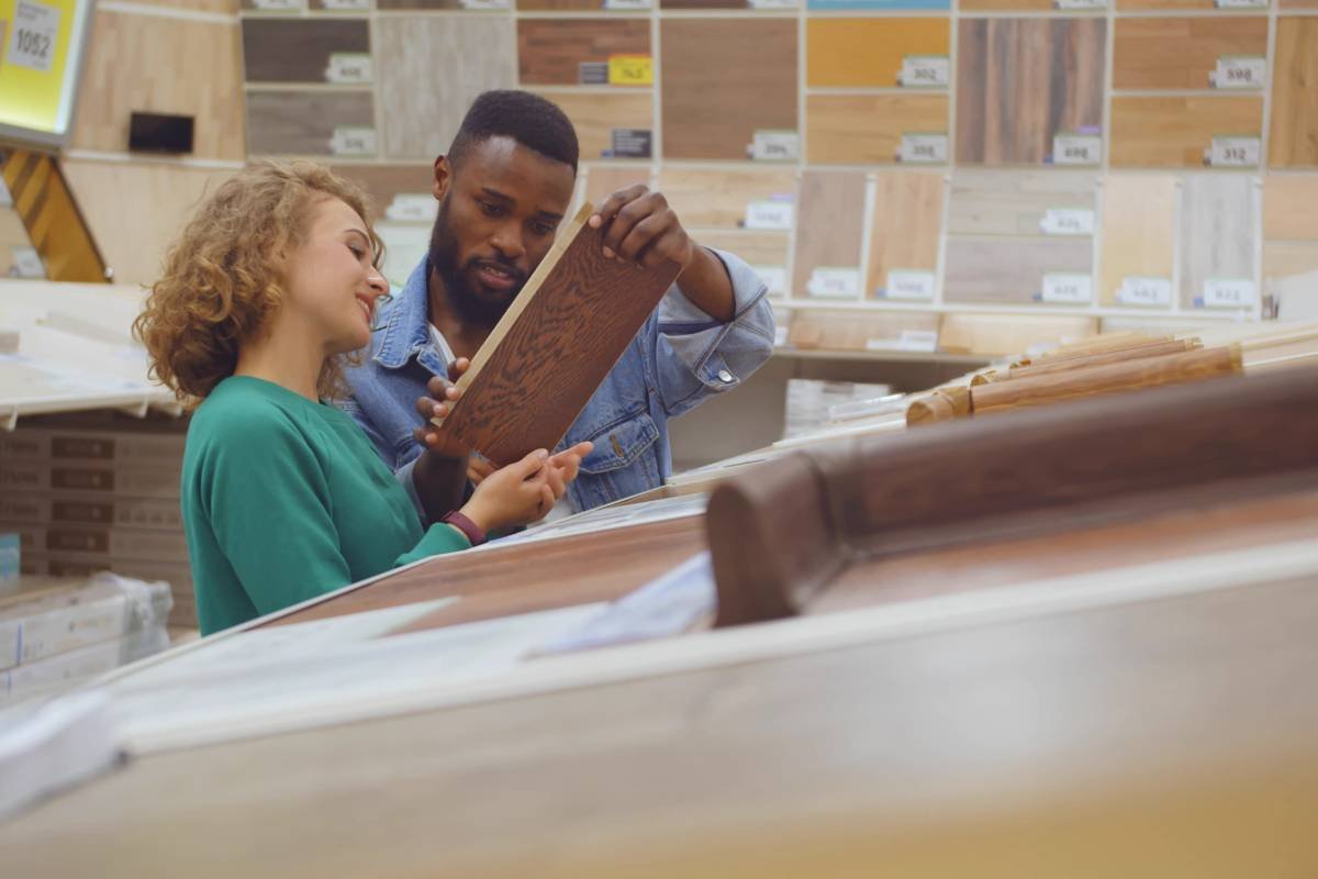 A couple browsing various custom genuine and faux hardwood flooring options together for their home